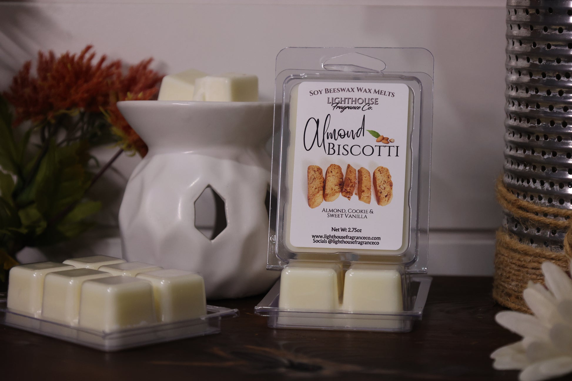 Almond Biscotti wax melts in packaging with a white wax warmer on a wooden surface.