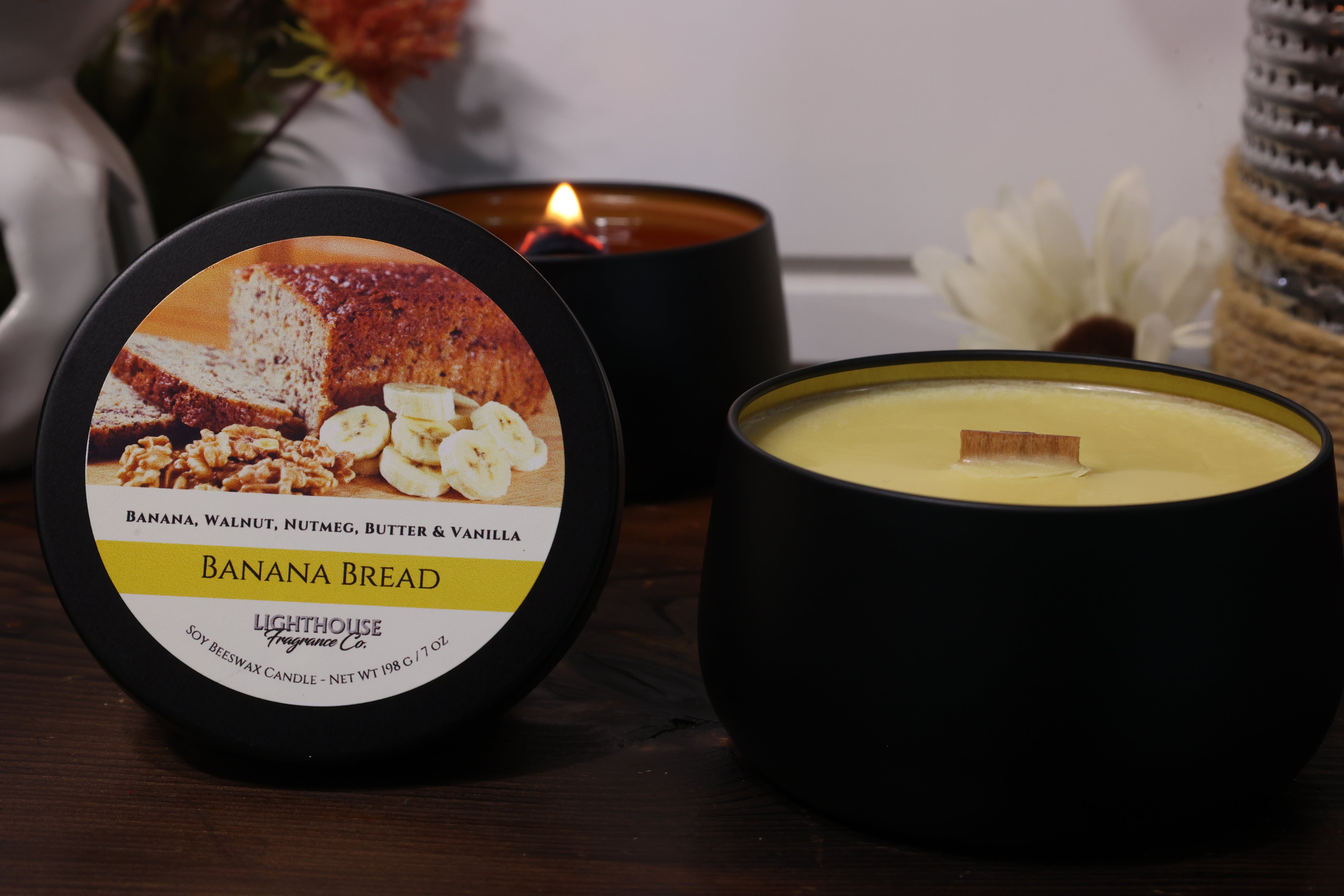 Banana bread-scented candle with packaging on a wooden surface