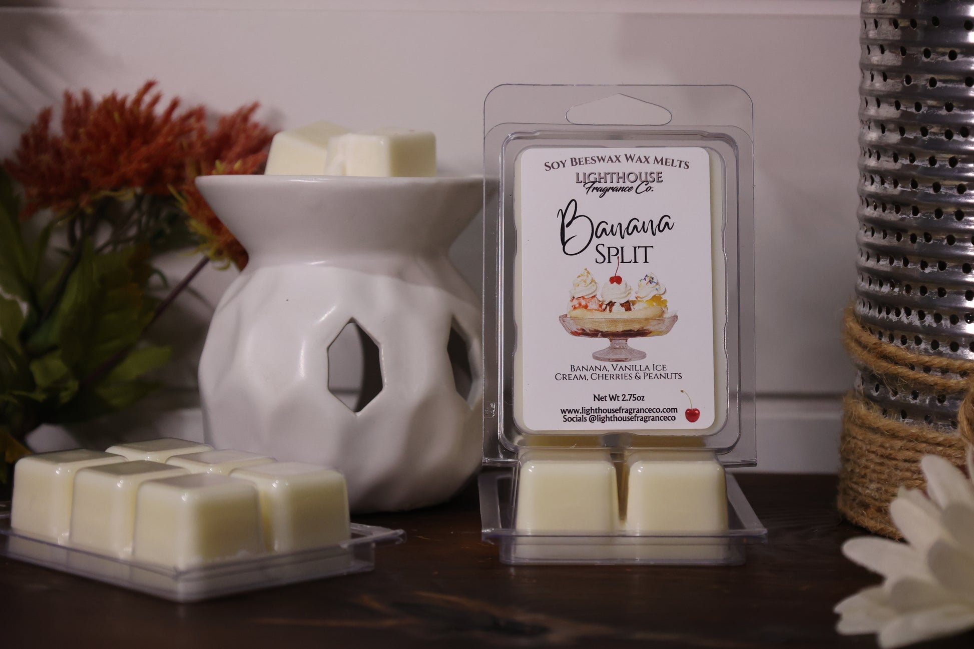 Scented wax melts in packaging with a white wax warmer on a wooden surface.