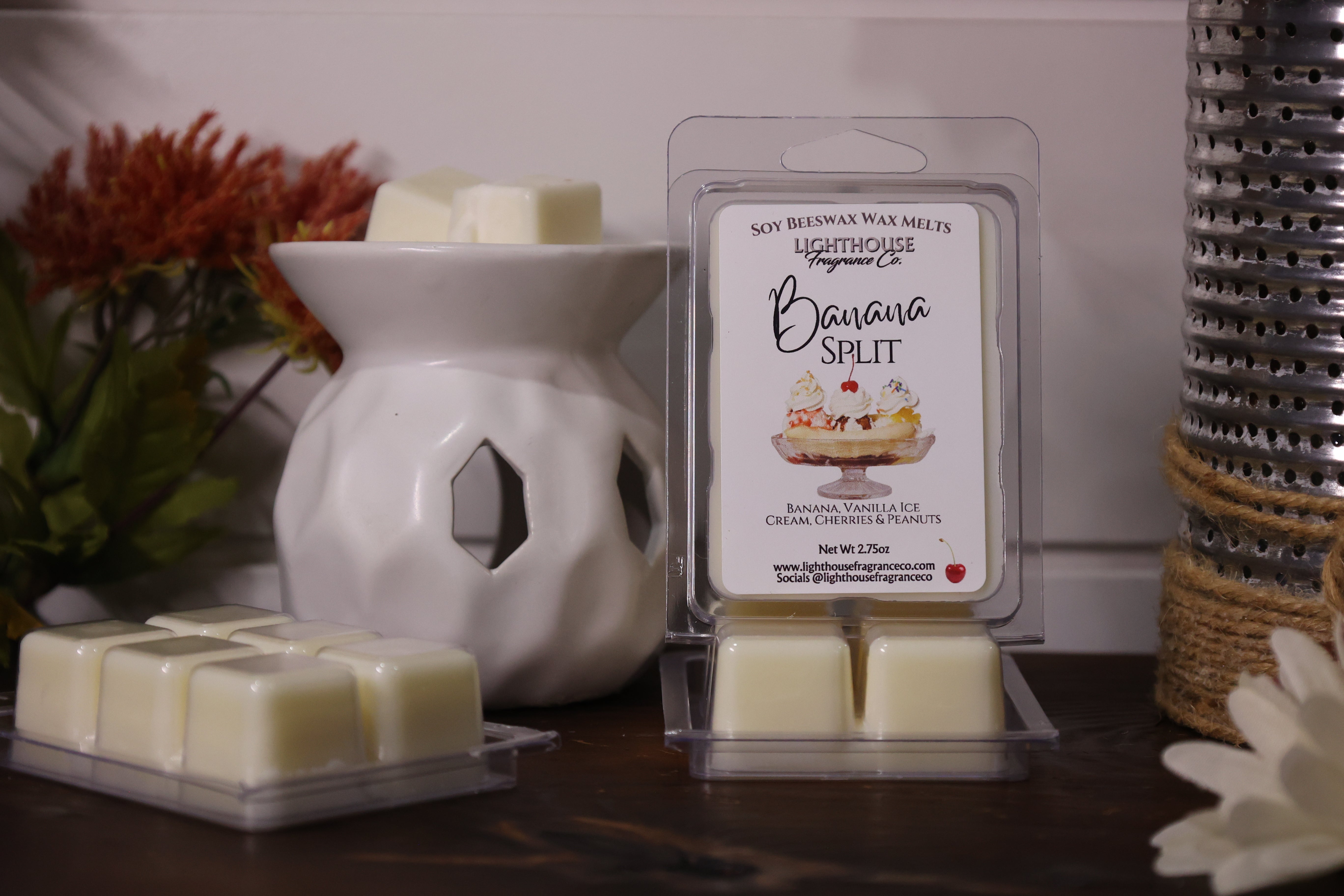 Scented wax melts in packaging with a white wax warmer on a wooden surface.