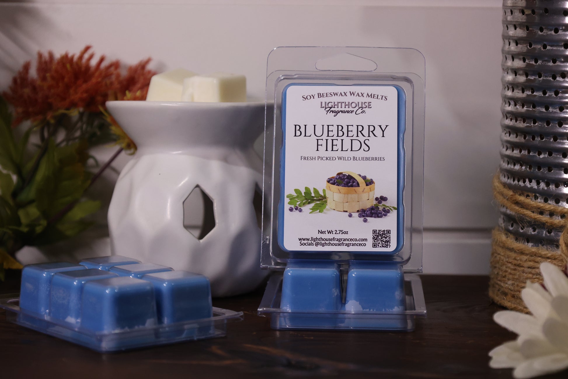 Blueberry Fields wax melts packaging with a white wax warmer on a wooden surface.
