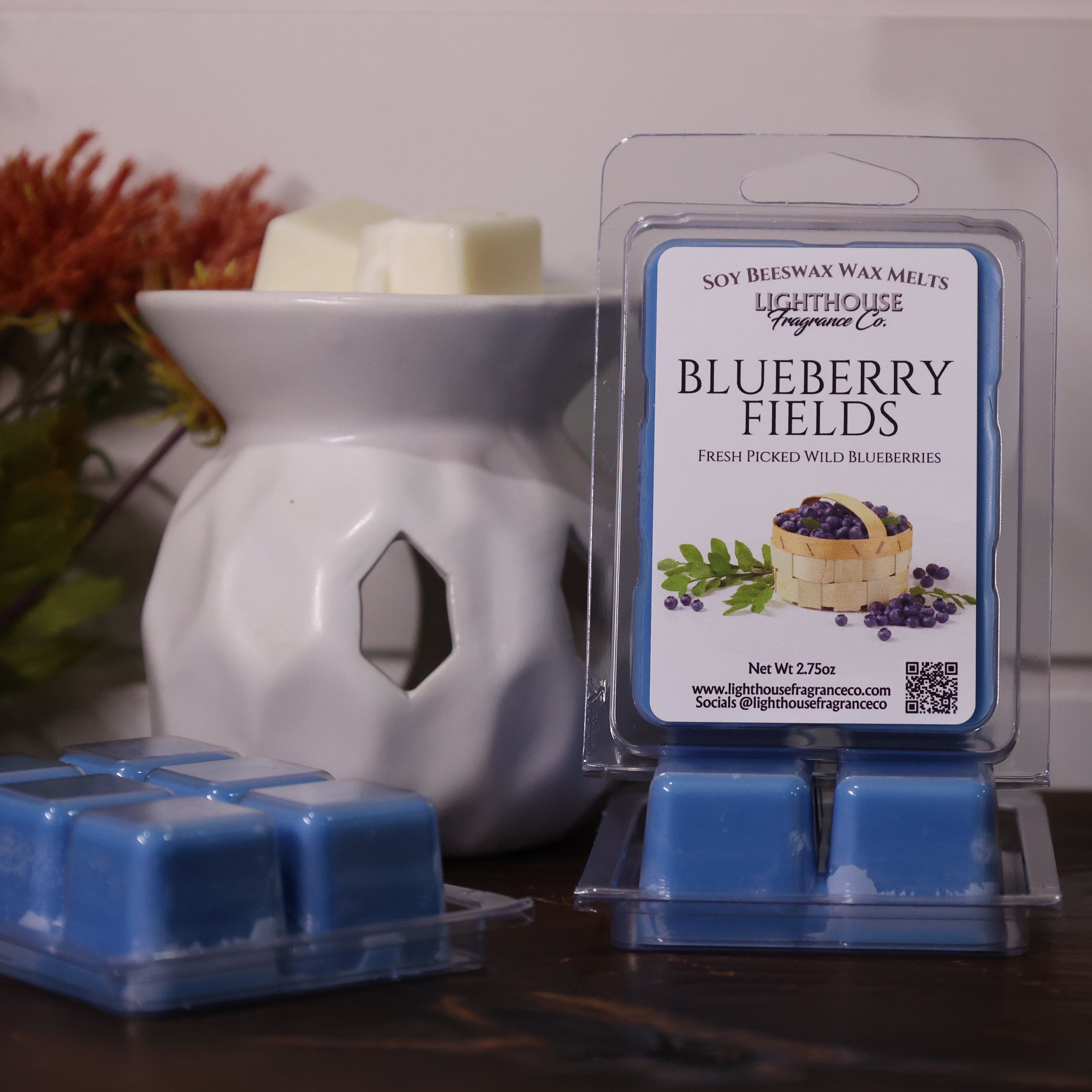 Blueberry Fields wax melts packaging with a white wax warmer on a wooden surface.