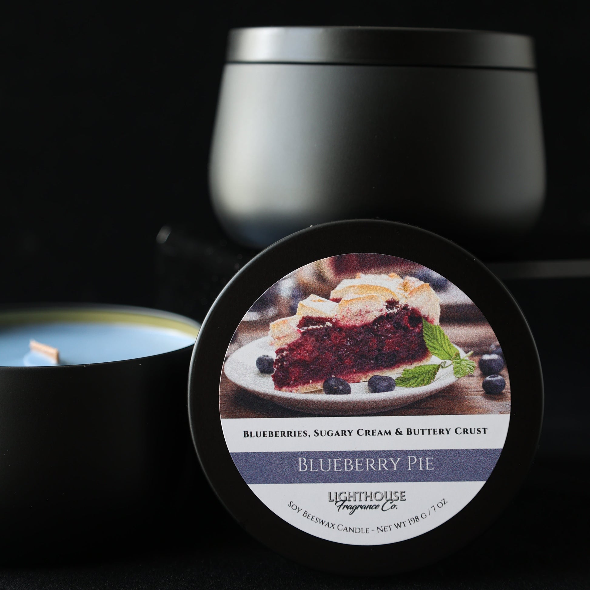 black candle tin, blue wax, candle named blueberry pie