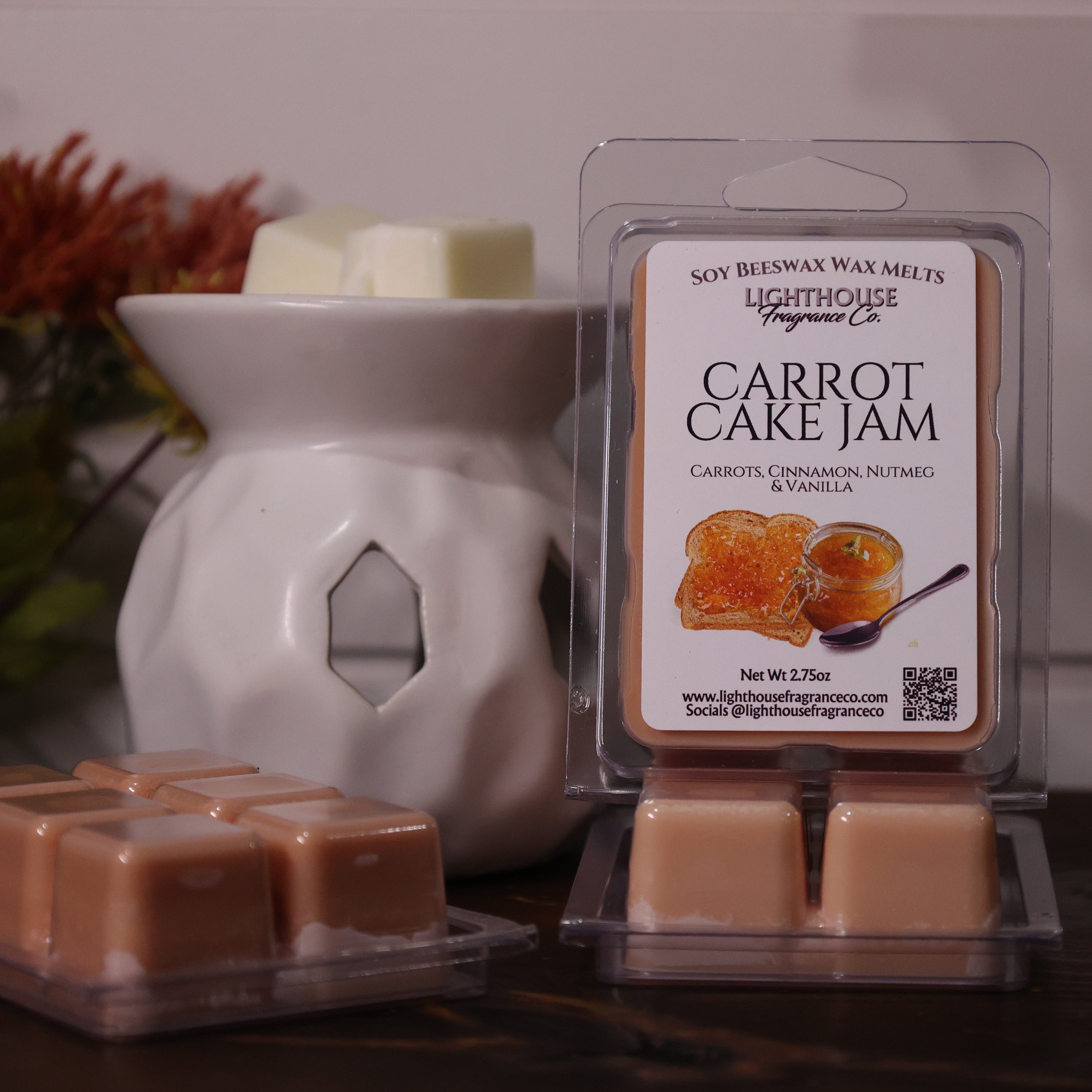 Carrot cake jam wax melts with packaging and a wax warmer on a wooden surface.