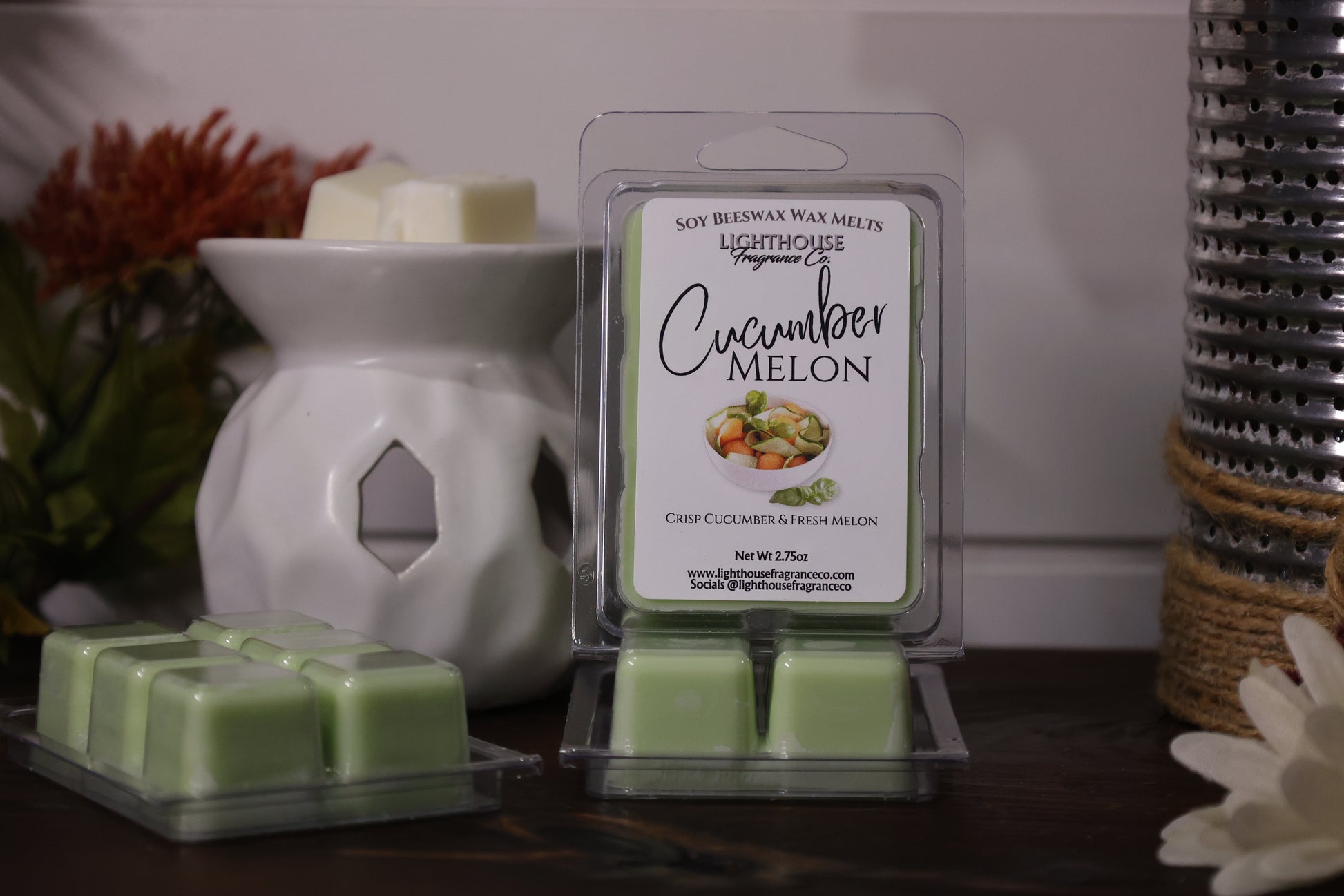 Cucumber Melon wax melts packaging with a white wax warmer and flowers in the background
