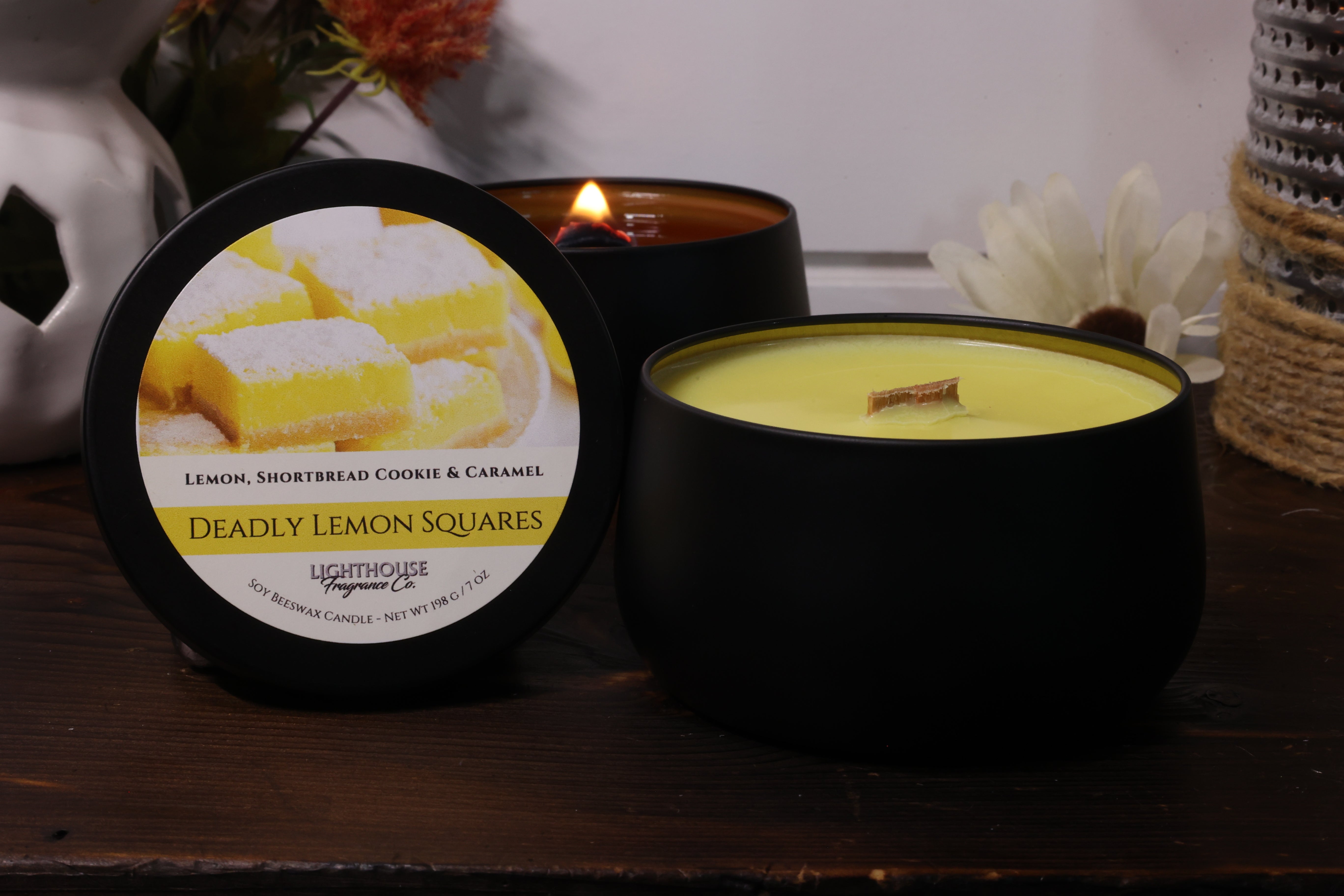 Candle with a labeled container on a wooden surface
