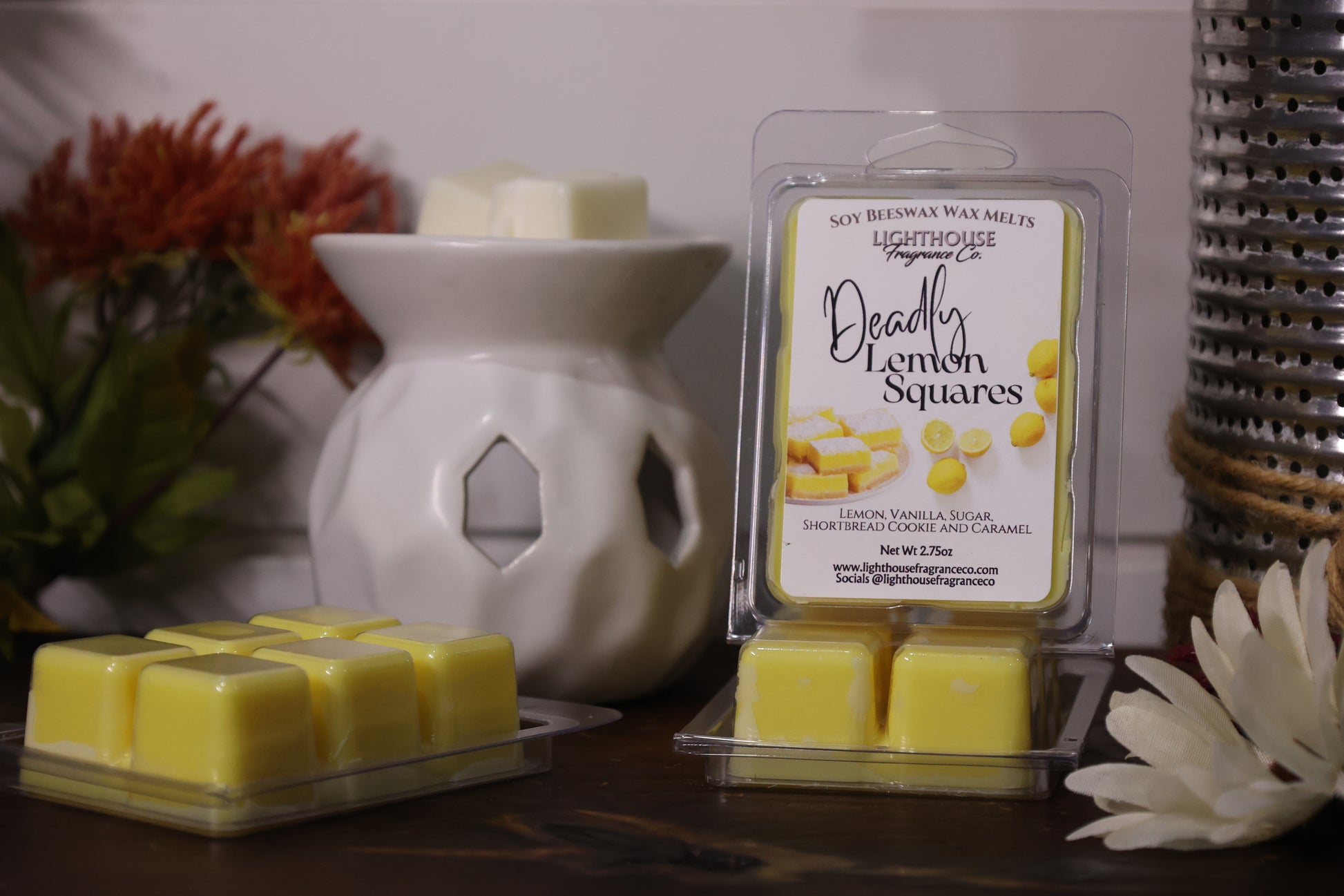 Packaged lemon wax melts with a diffuser and decorative items on a surface.