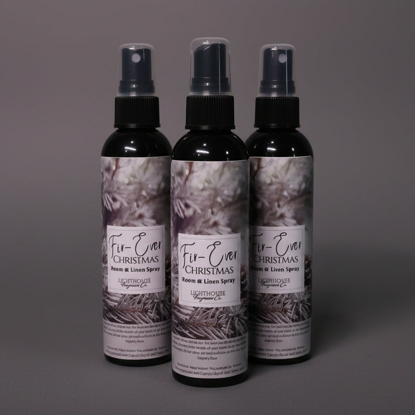 Three bottles of Fir-Ever Christmas room spray on a dark grey surface