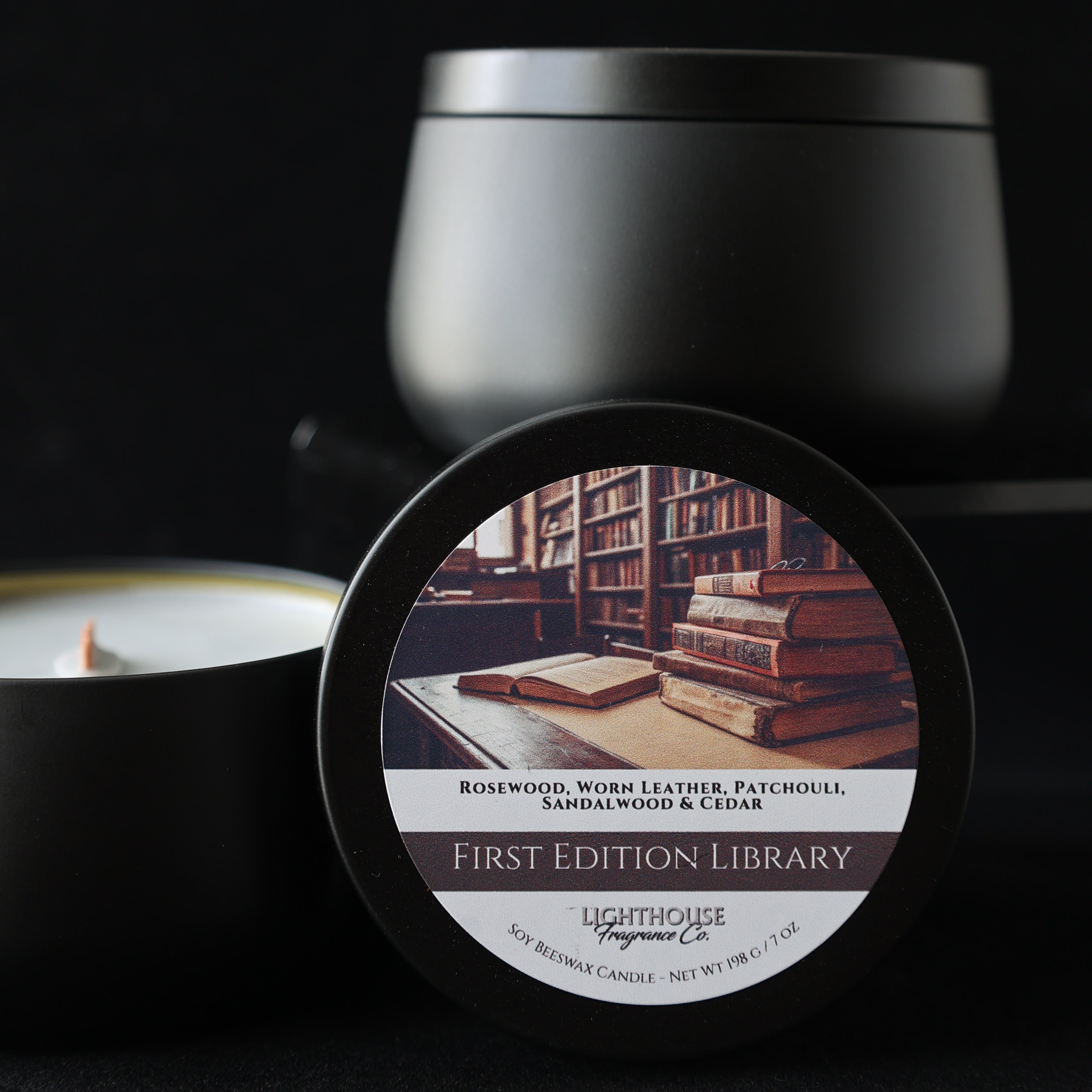 First Edition Library Candle in a black tin against a black background