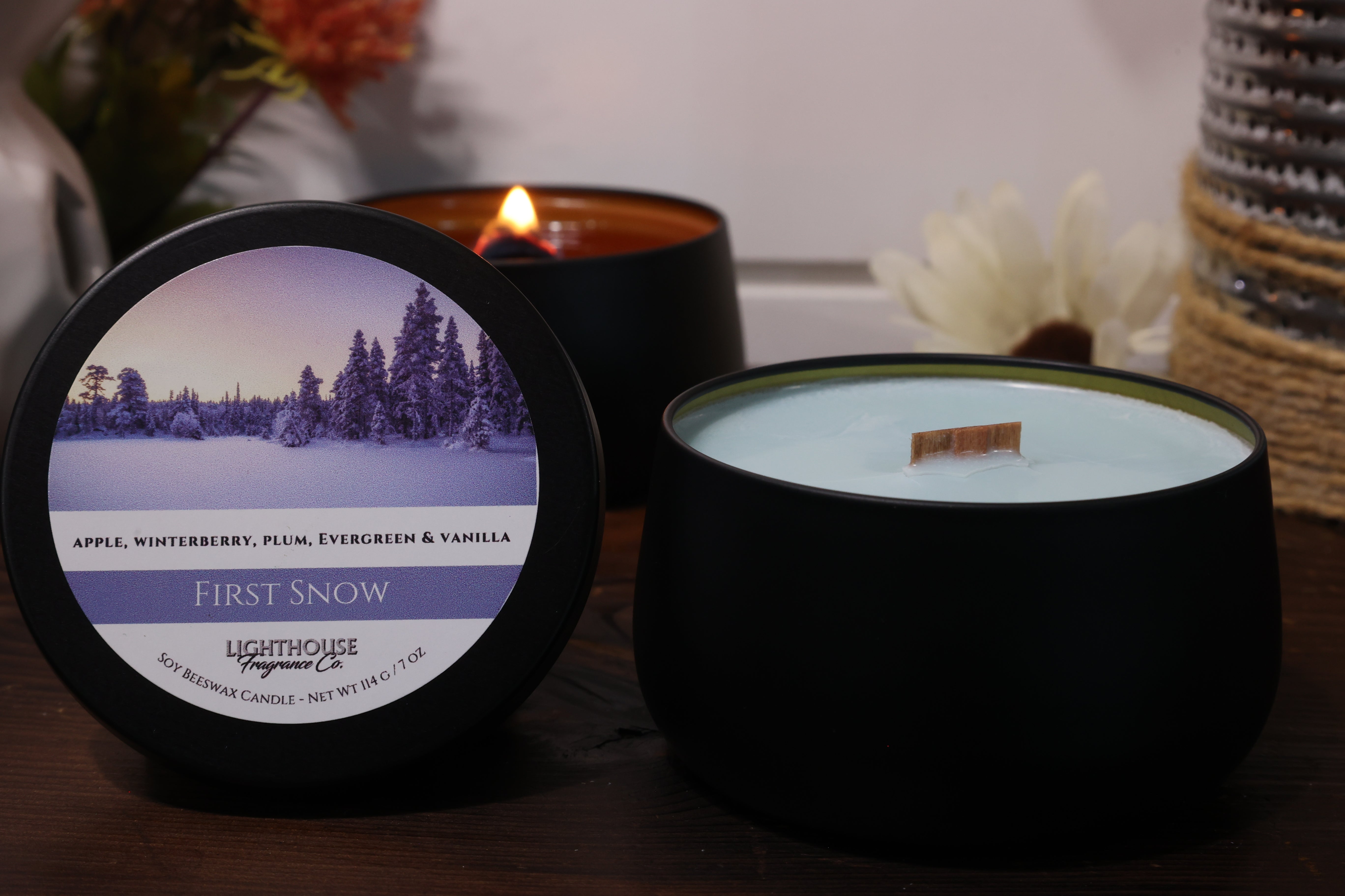 Two candles with labels on a wooden surface