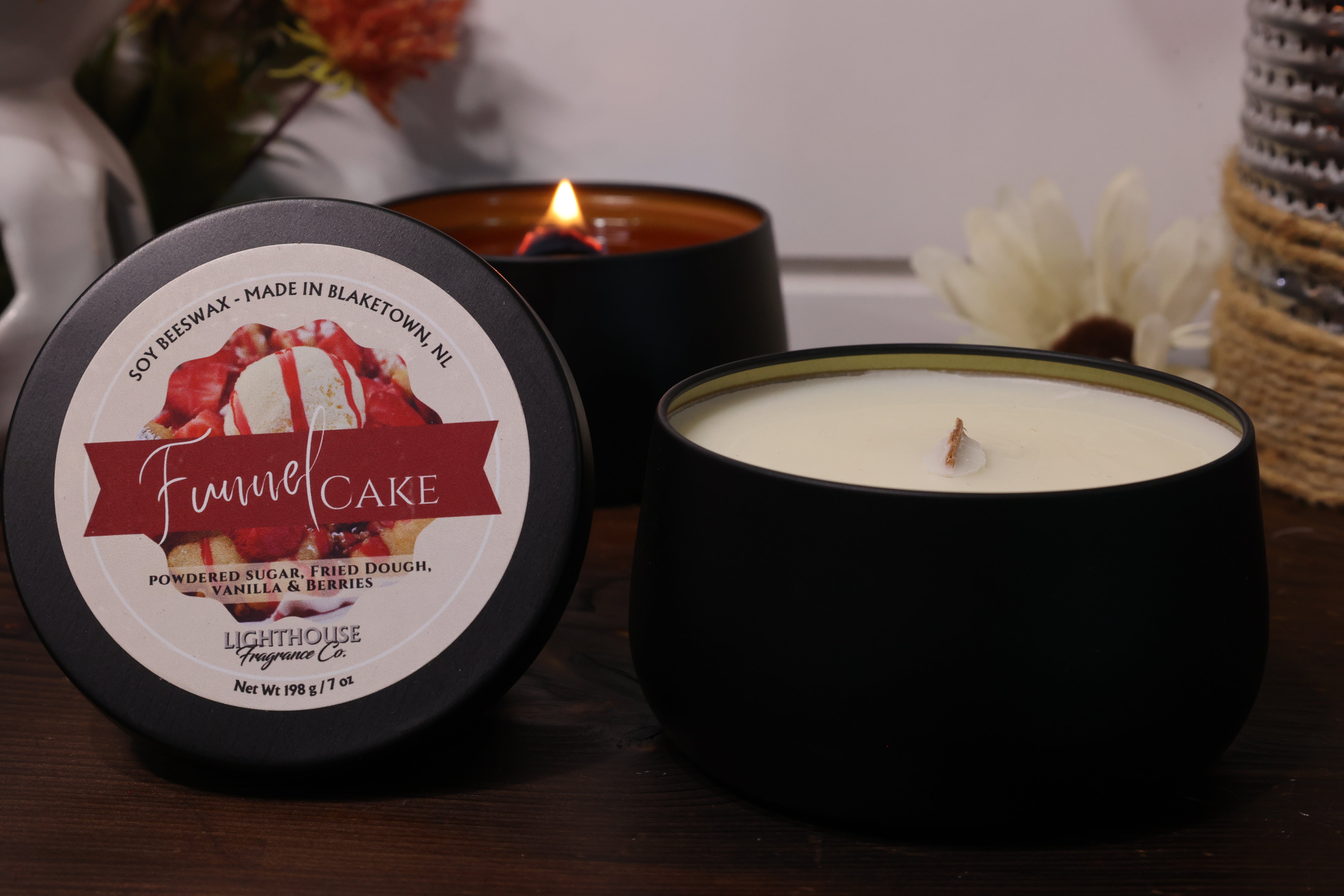 Funnel cake-flavored candle with packaging on a wooden surface