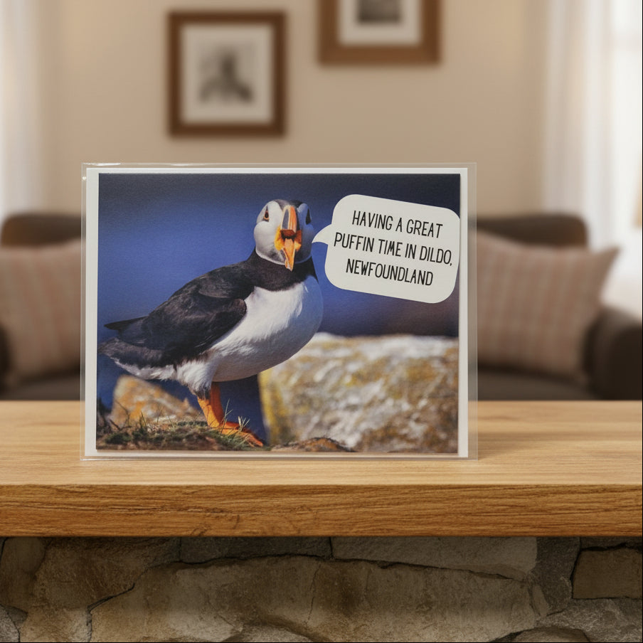 Card with a puffin and text 'Having a great puffin time in Dildo, Newfoundland' with a living room in the background
