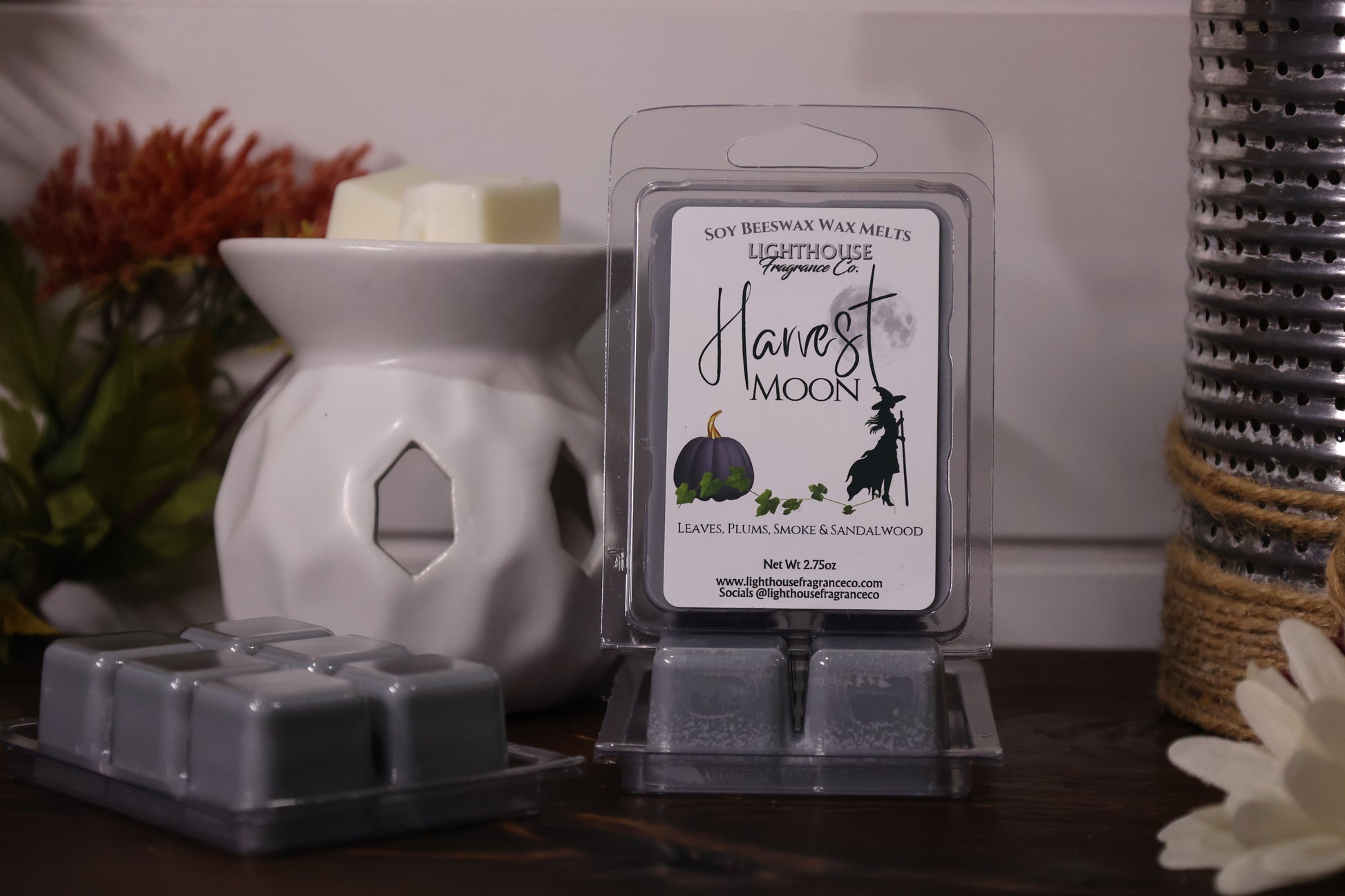 Soy wax melts packaging with a white wax warmer and decorative elements on a table.