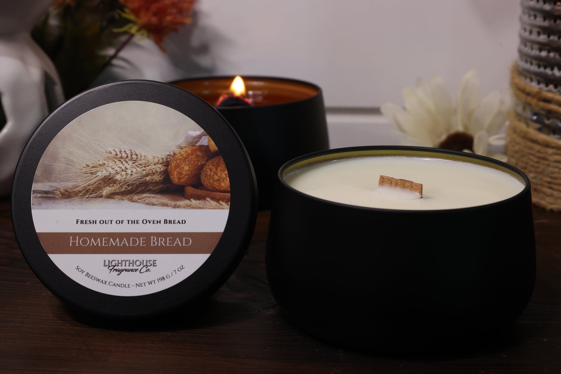 Candle with a label featuring bread imagery on a wooden surface.