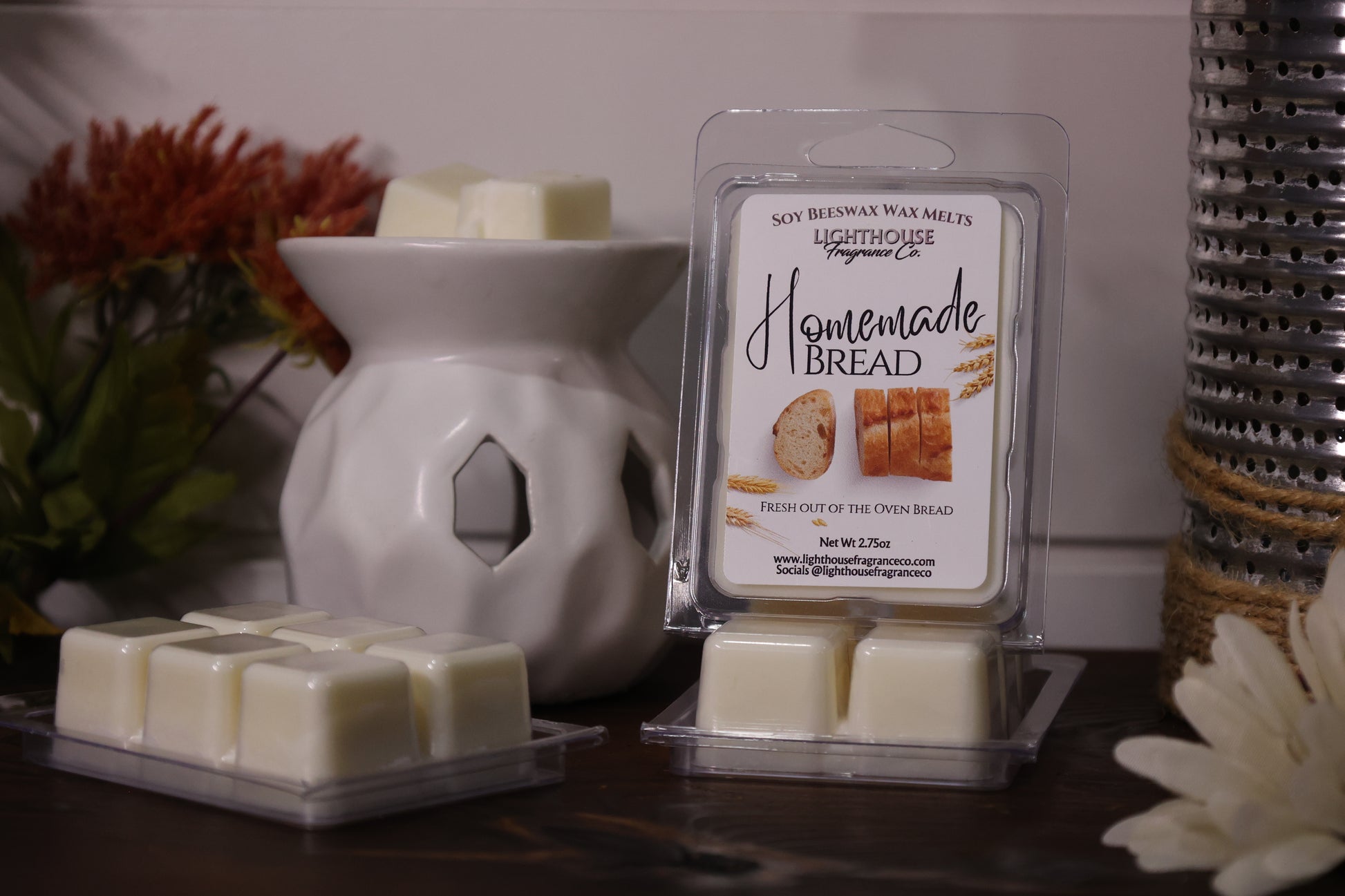Homemade bread-scented wax melts with packaging and a wax warmer on a wooden surface.