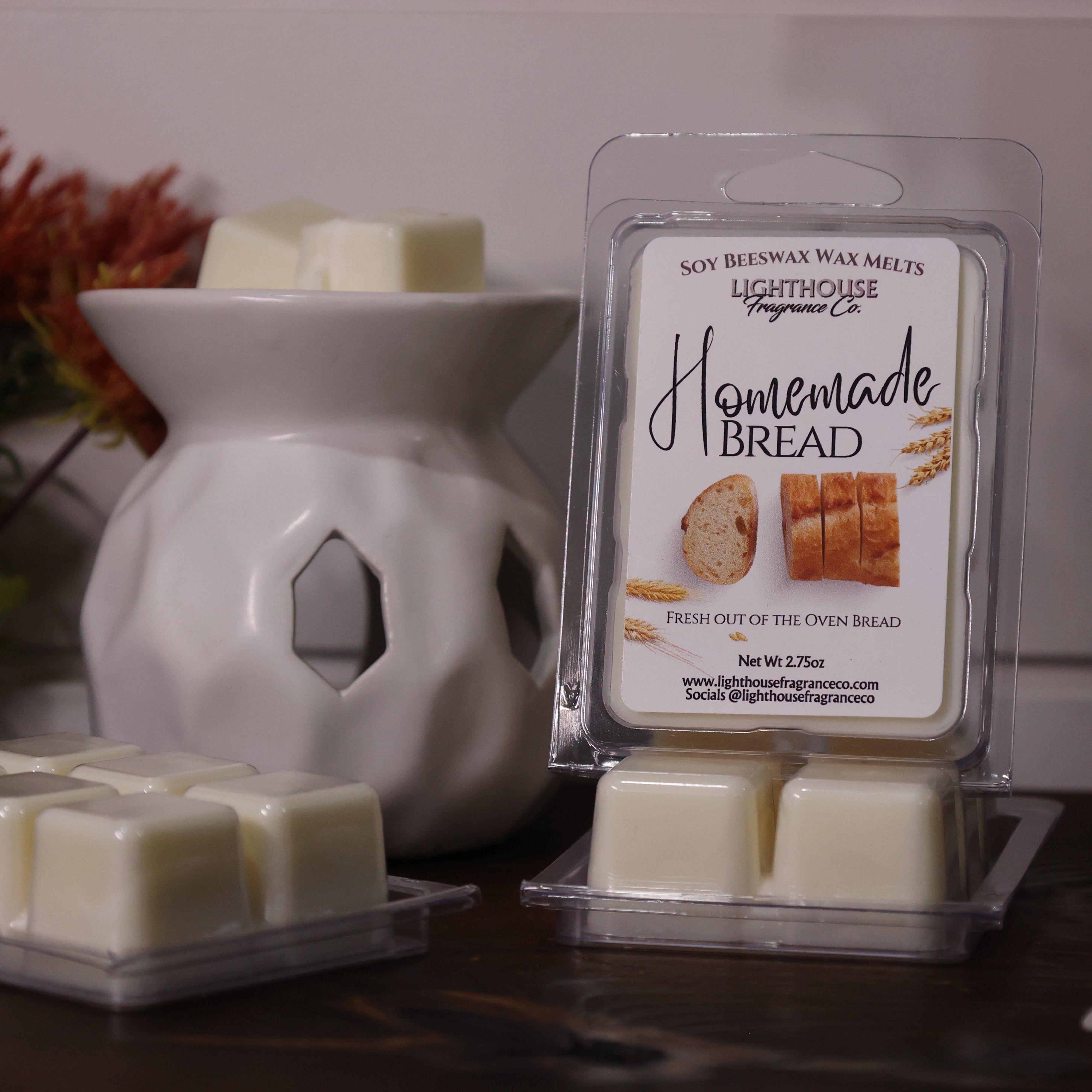 Homemade bread-scented wax melts with packaging and a wax warmer on a wooden surface.