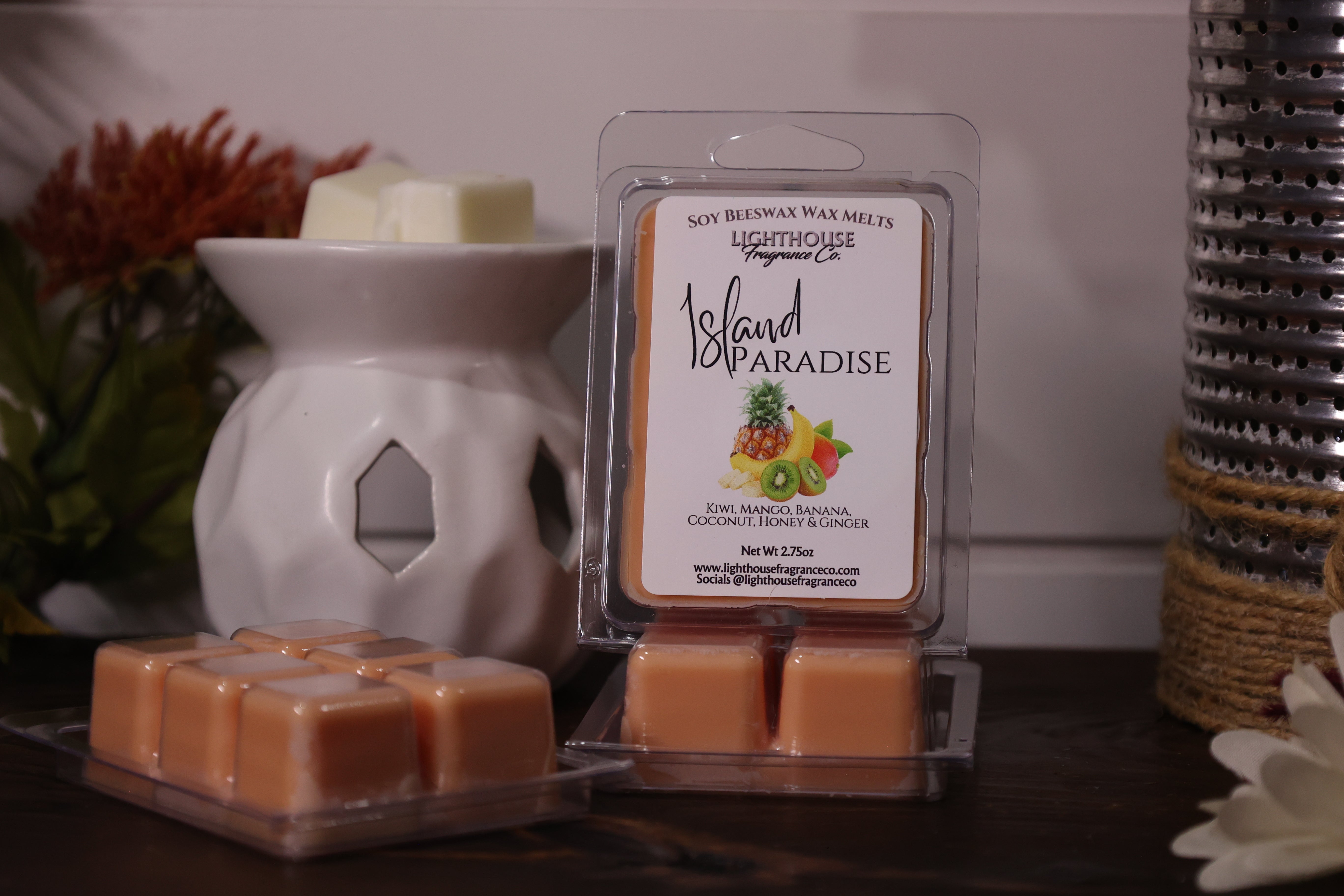 Packaged wax melts labeled 'Island Paradise' with a wax warmer on a wooden surface.