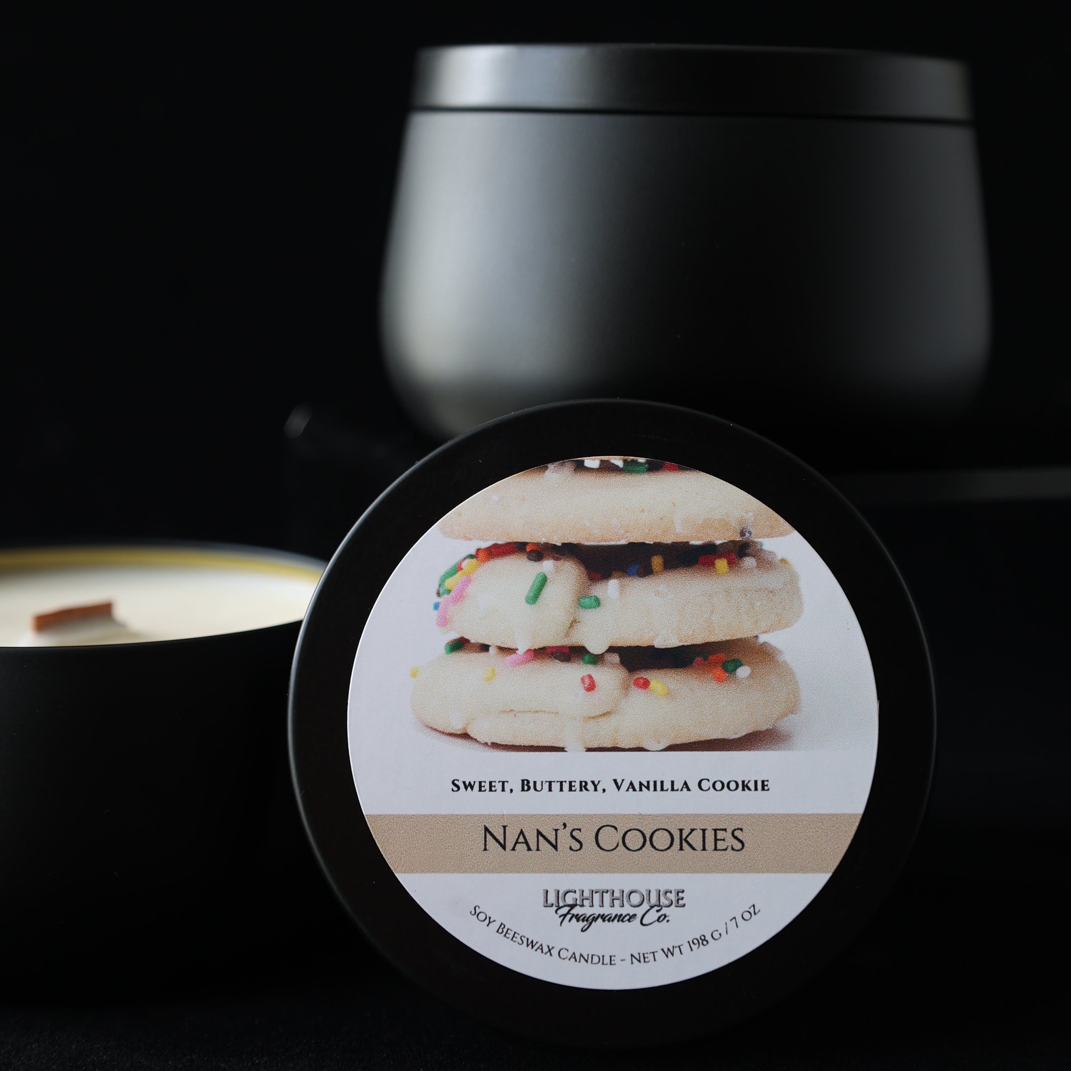Close-up of a candle with a label featuring a cookie design on a black background