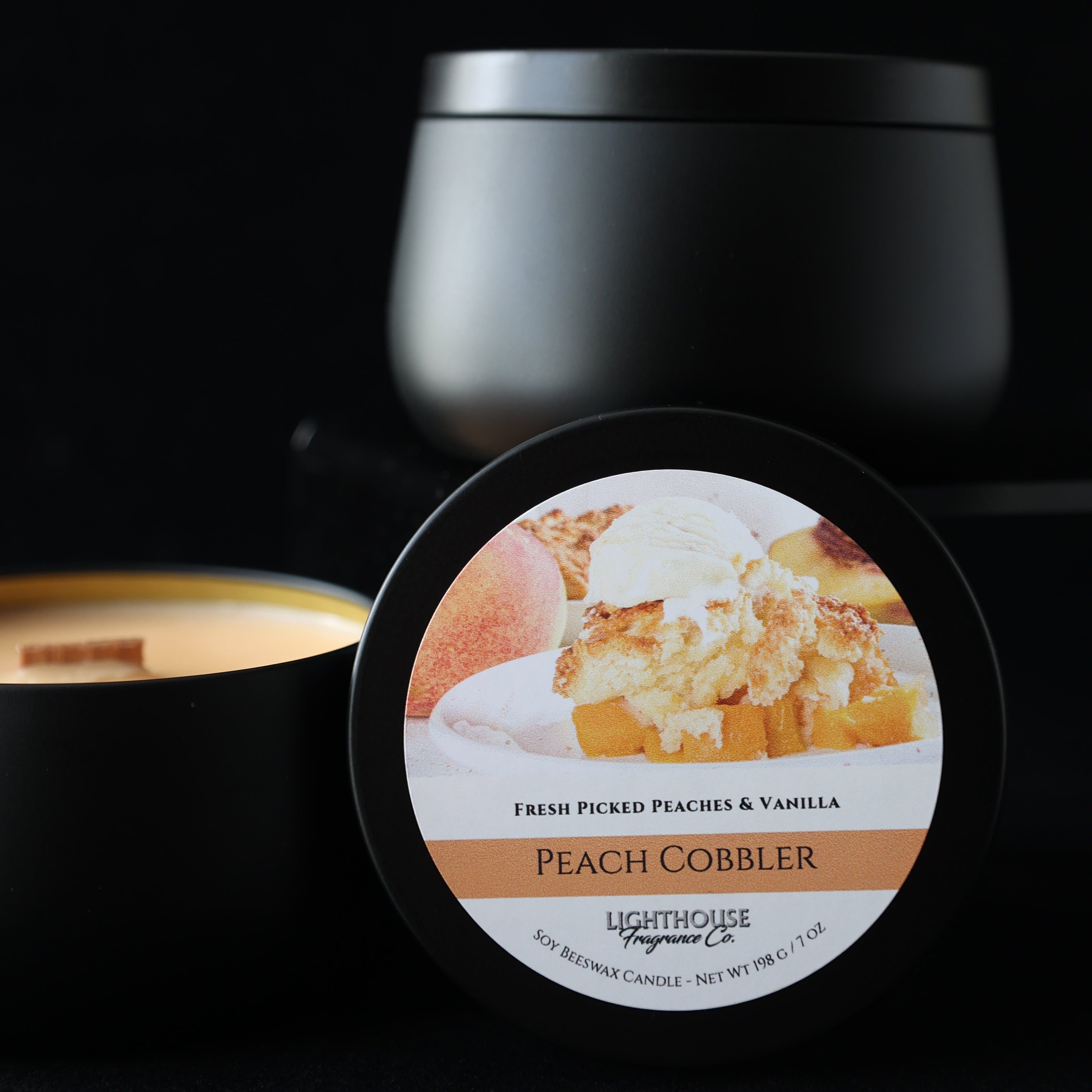 Peach Cobbler Candle in a black tin against a black background