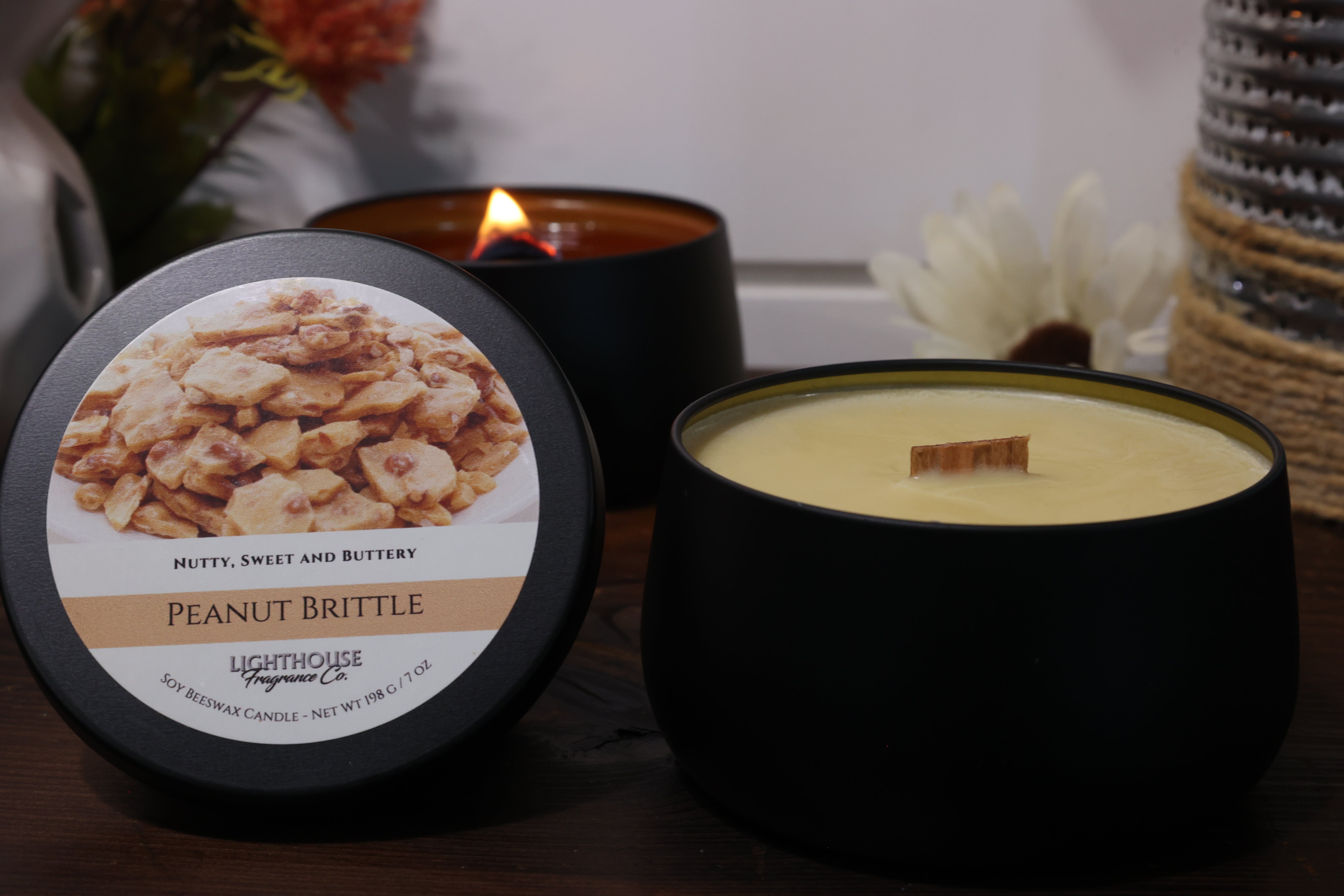 Peanut Brittle scented candle with packaging on a wooden surface
