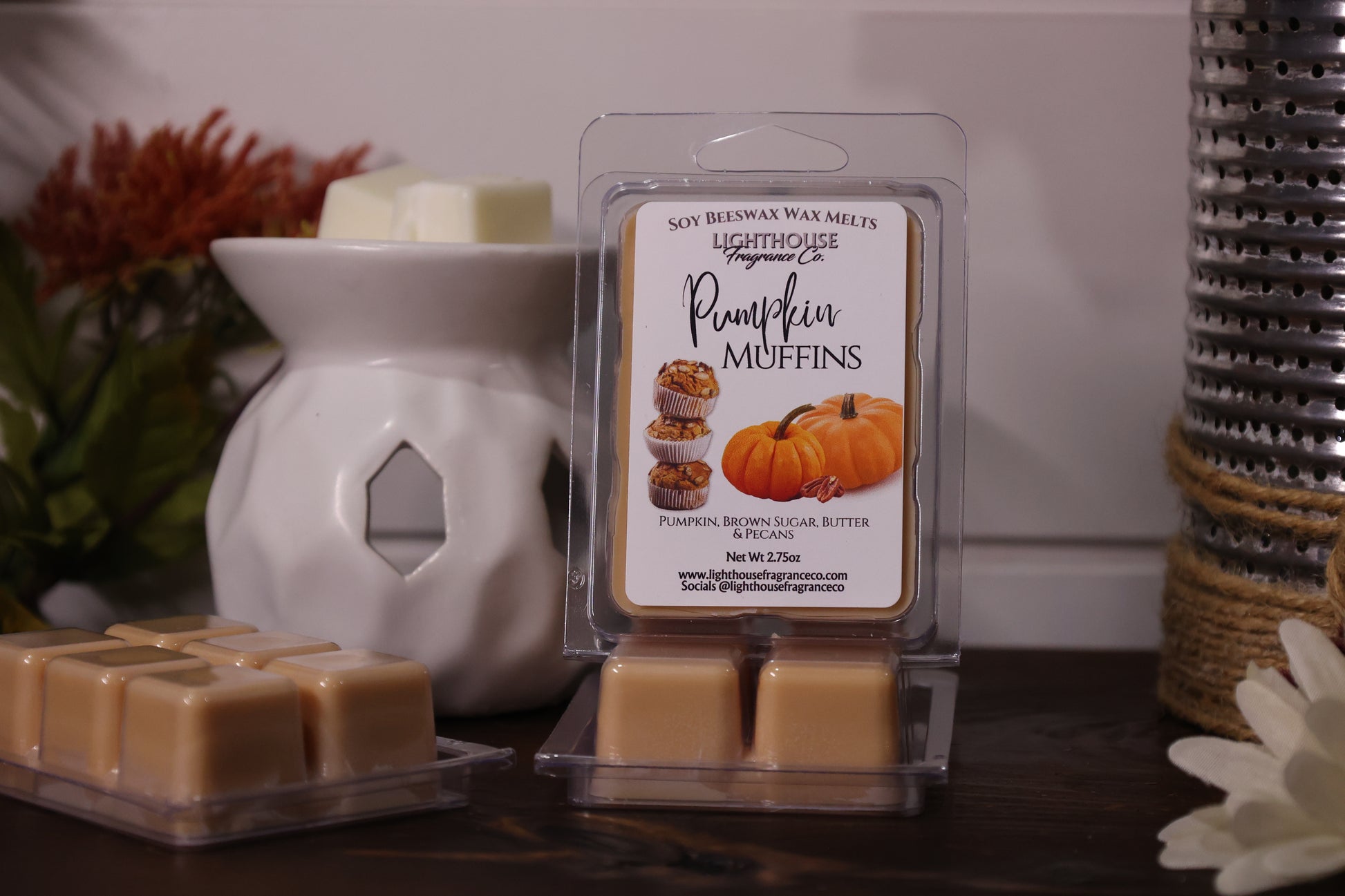 Packaged pumpkin muffin wax melts with a white wax warmer on a wooden surface.