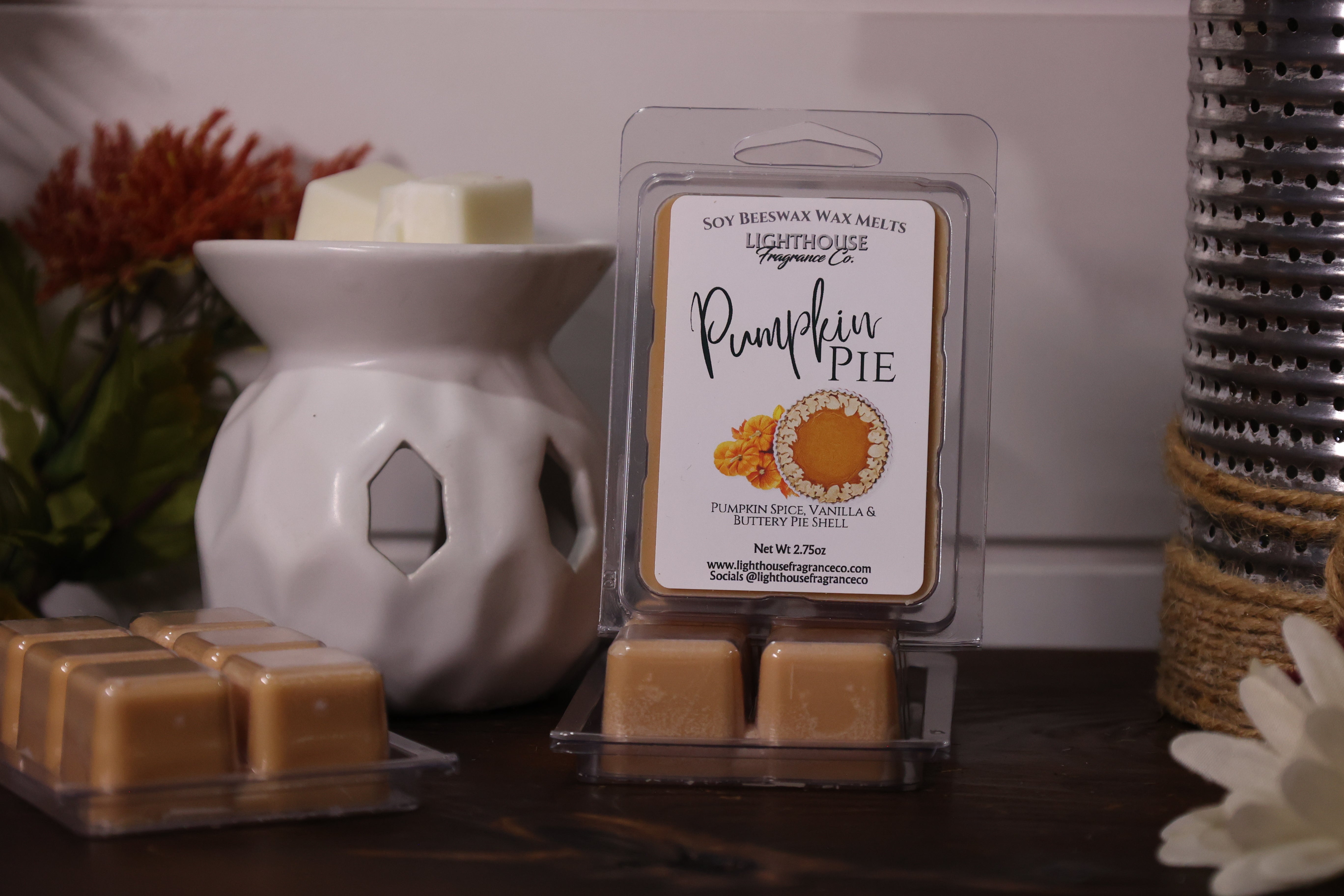 Pumpkin pie scented wax melts with a wax warmer on a wooden surface.