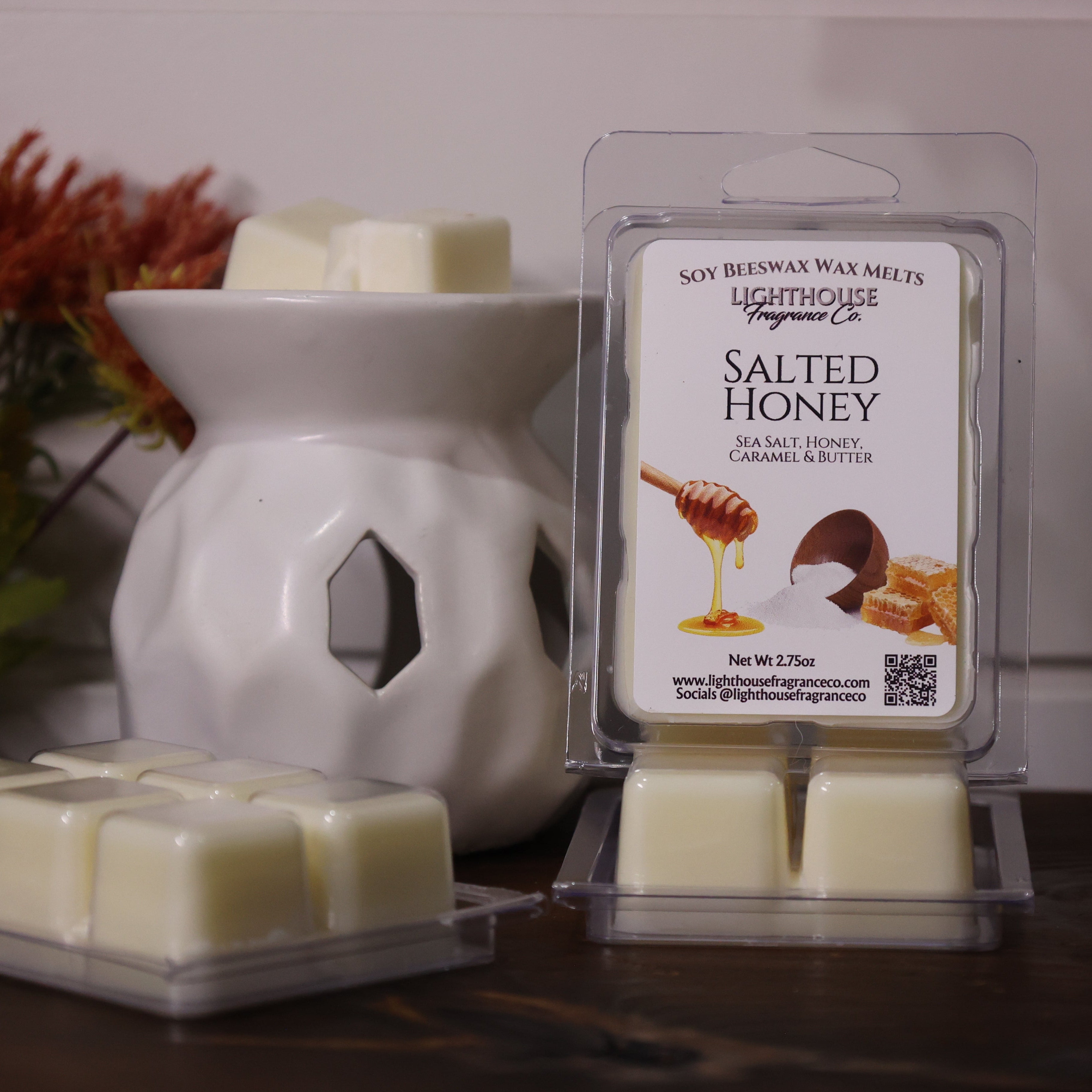 Salted honey wax melts in packaging with a white wax warmer on a wooden surface.