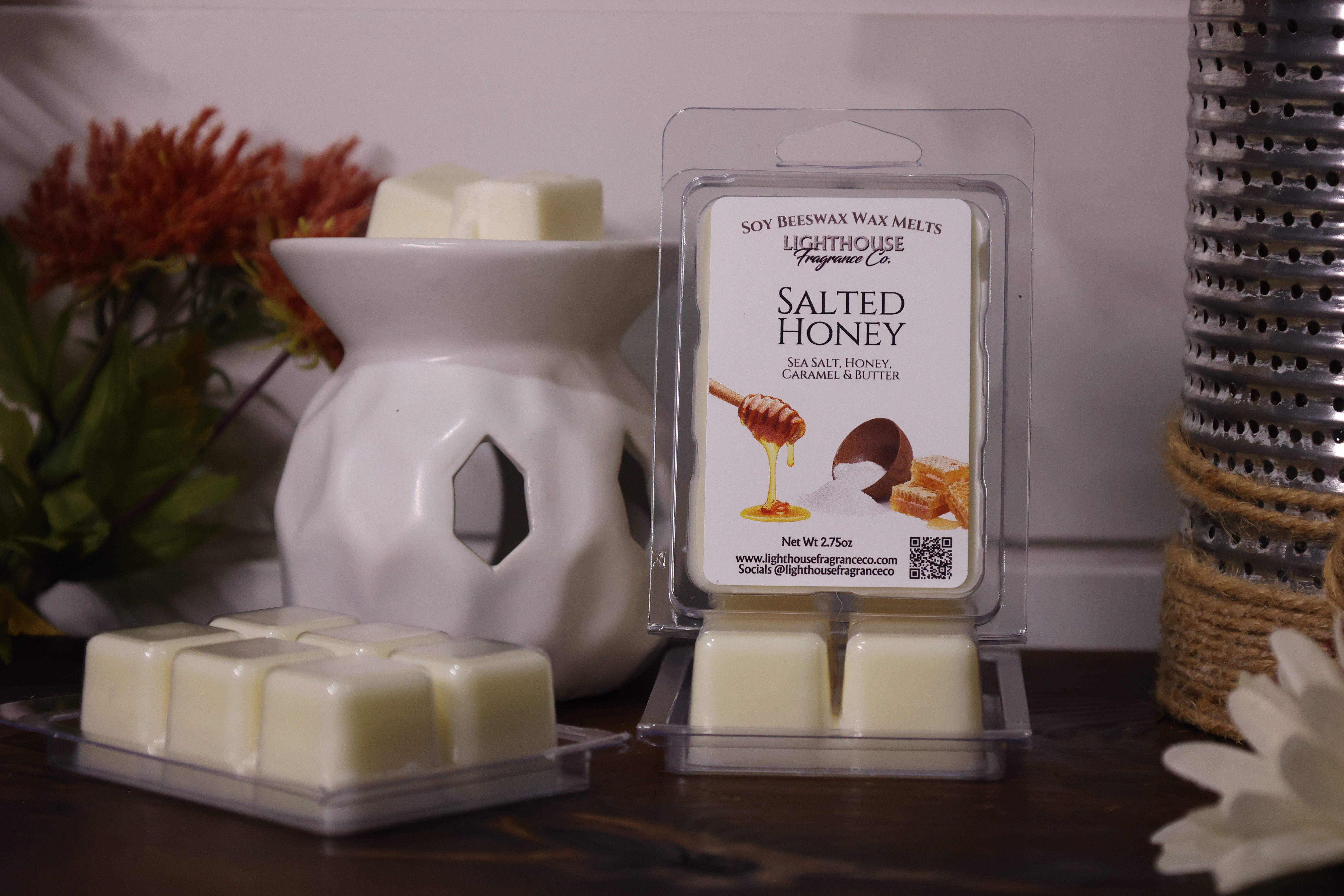 Salted honey wax melts in packaging with a white wax warmer on a wooden surface.