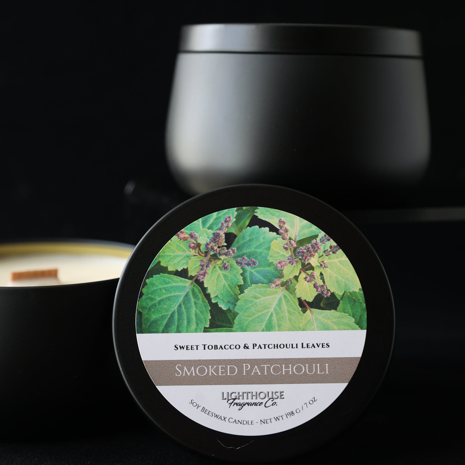 Jar of Smoked Patchouli candle with green leaf design on a black background