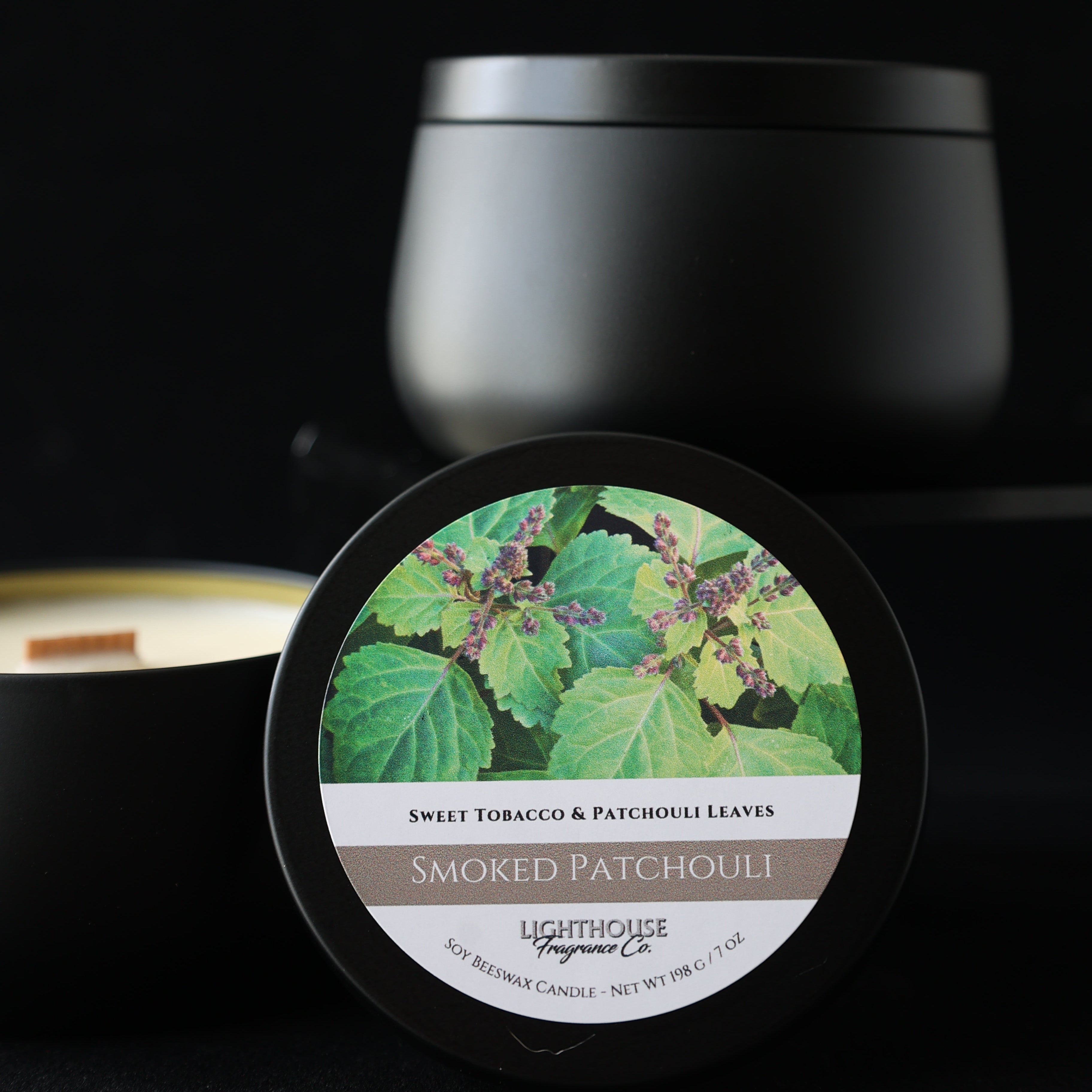 Jar of Smoked Patchouli candle with green leaf design on a black background