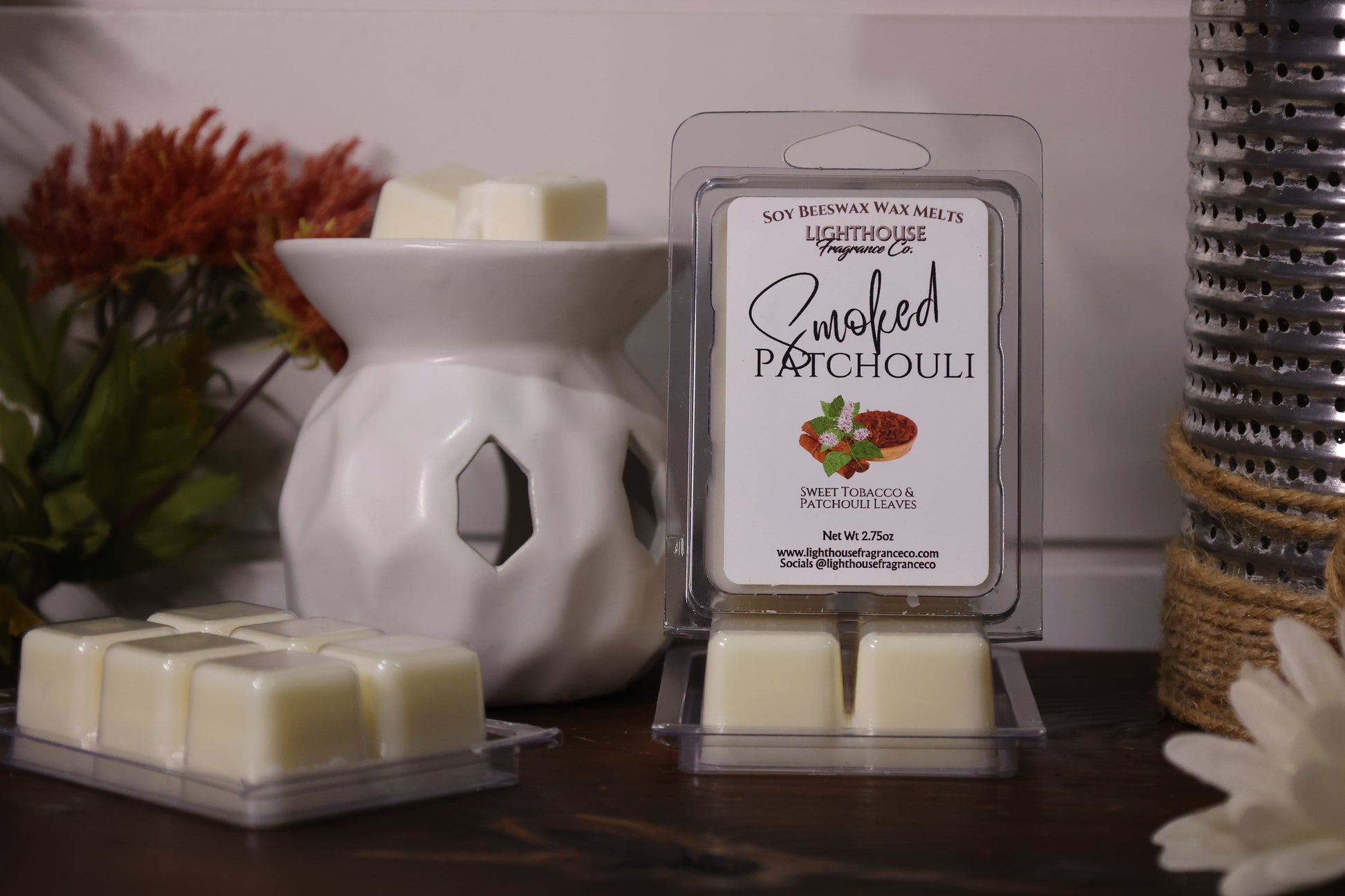 Wax melts packaging with a white wax melt burner and decorative elements.