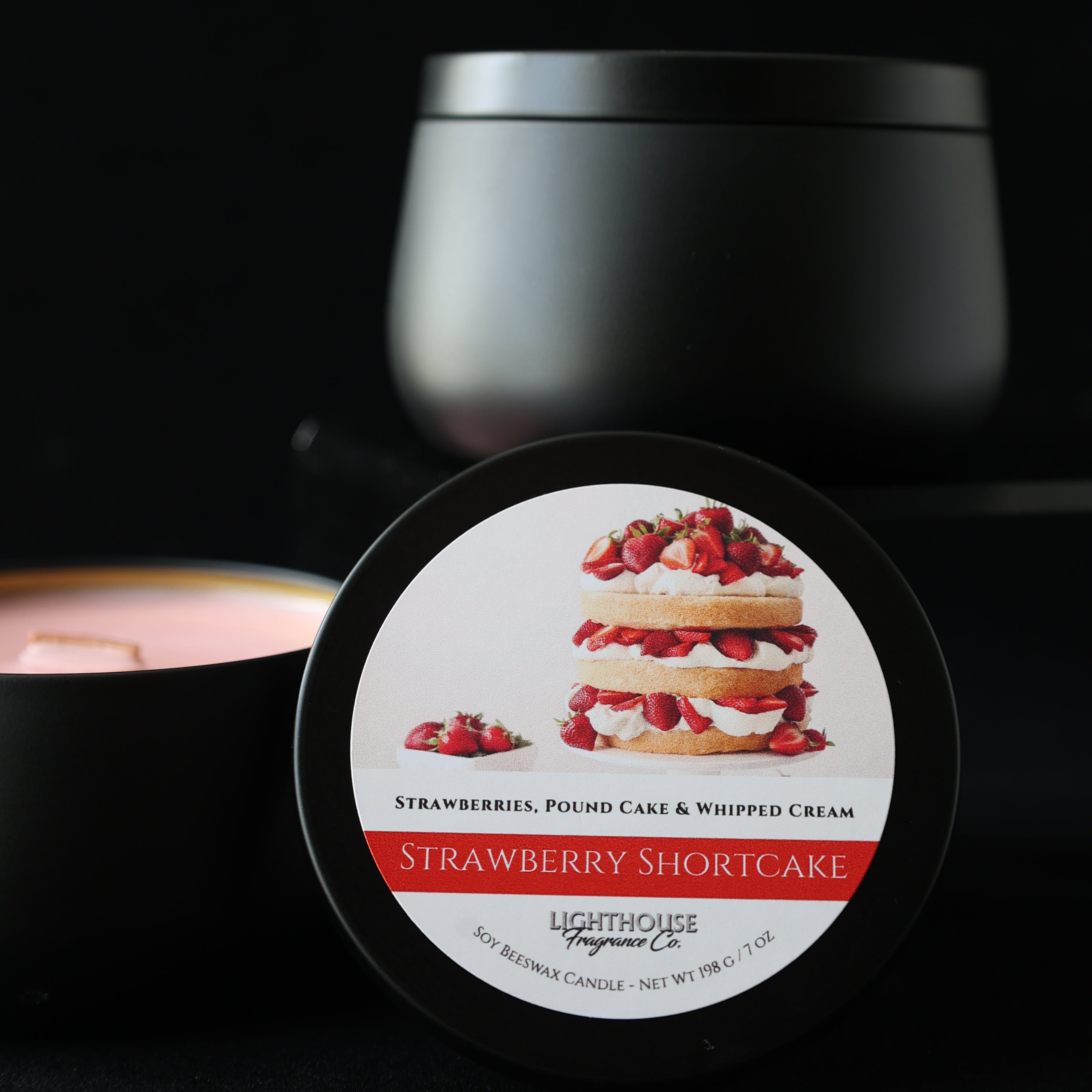 Strawberry Shortcake Candle  in a black tin against a black background