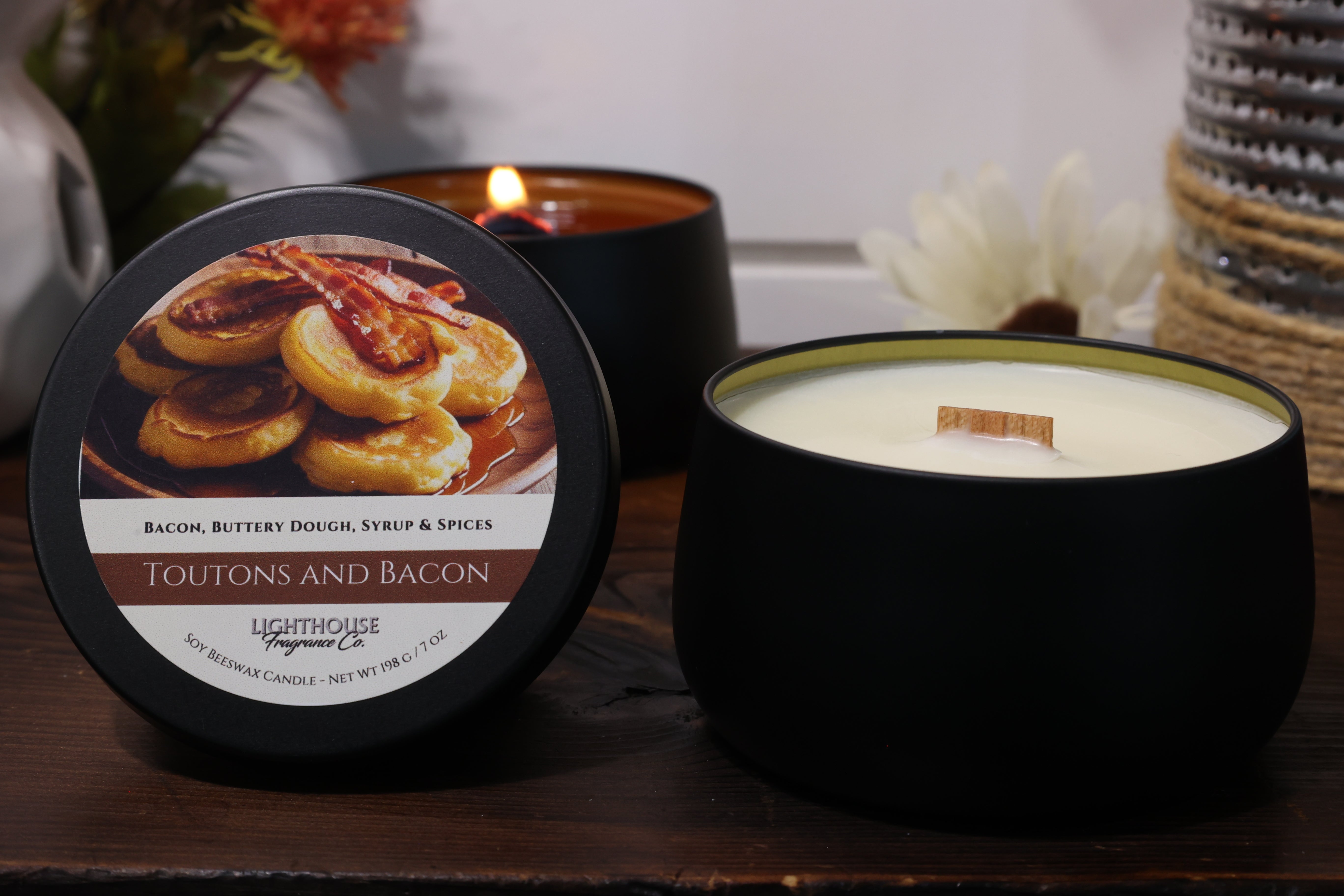 Candle with label featuring food imagery on a wooden surface