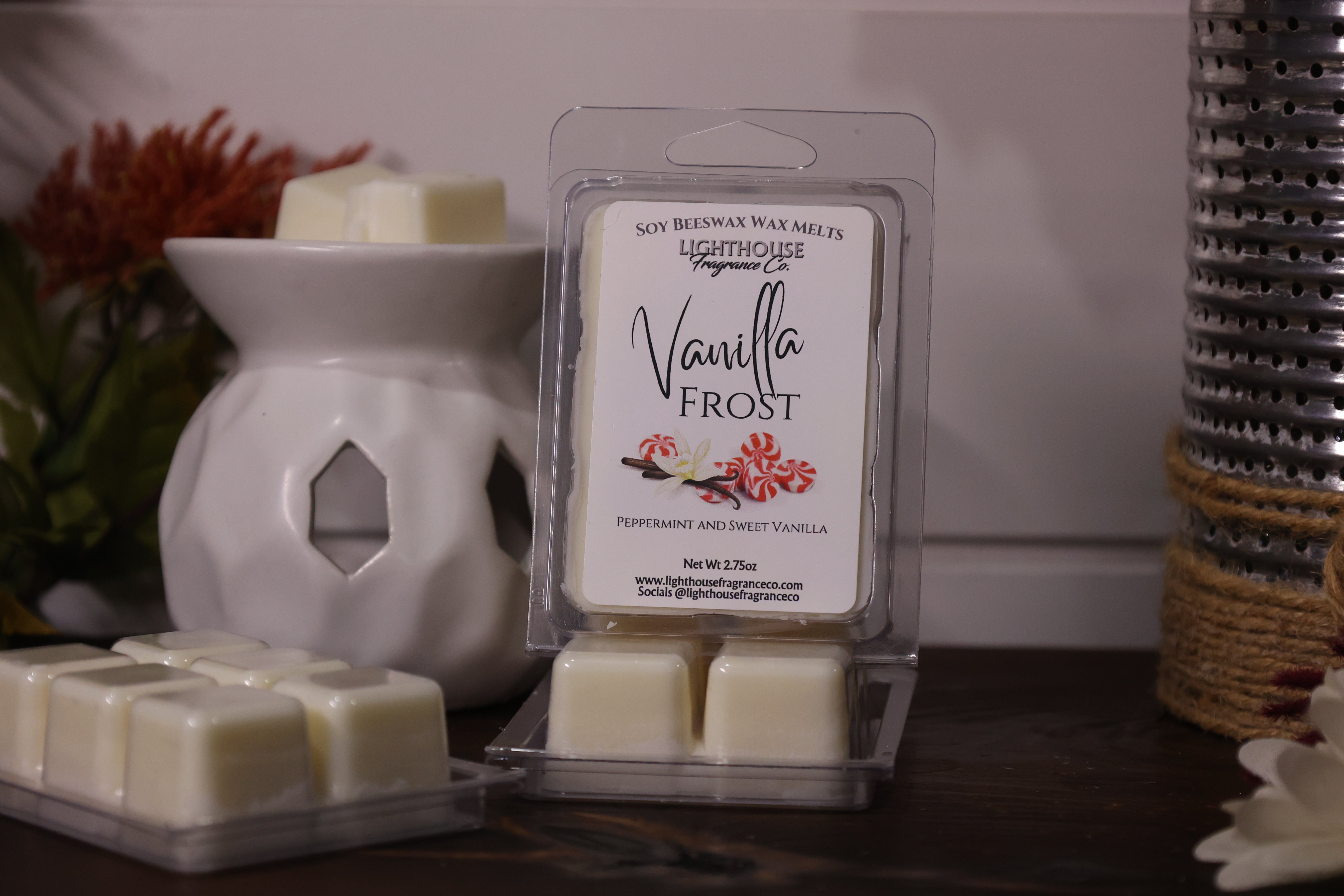 Packaged vanilla wax melt with a wax warmer and additional melts on a wooden surface.