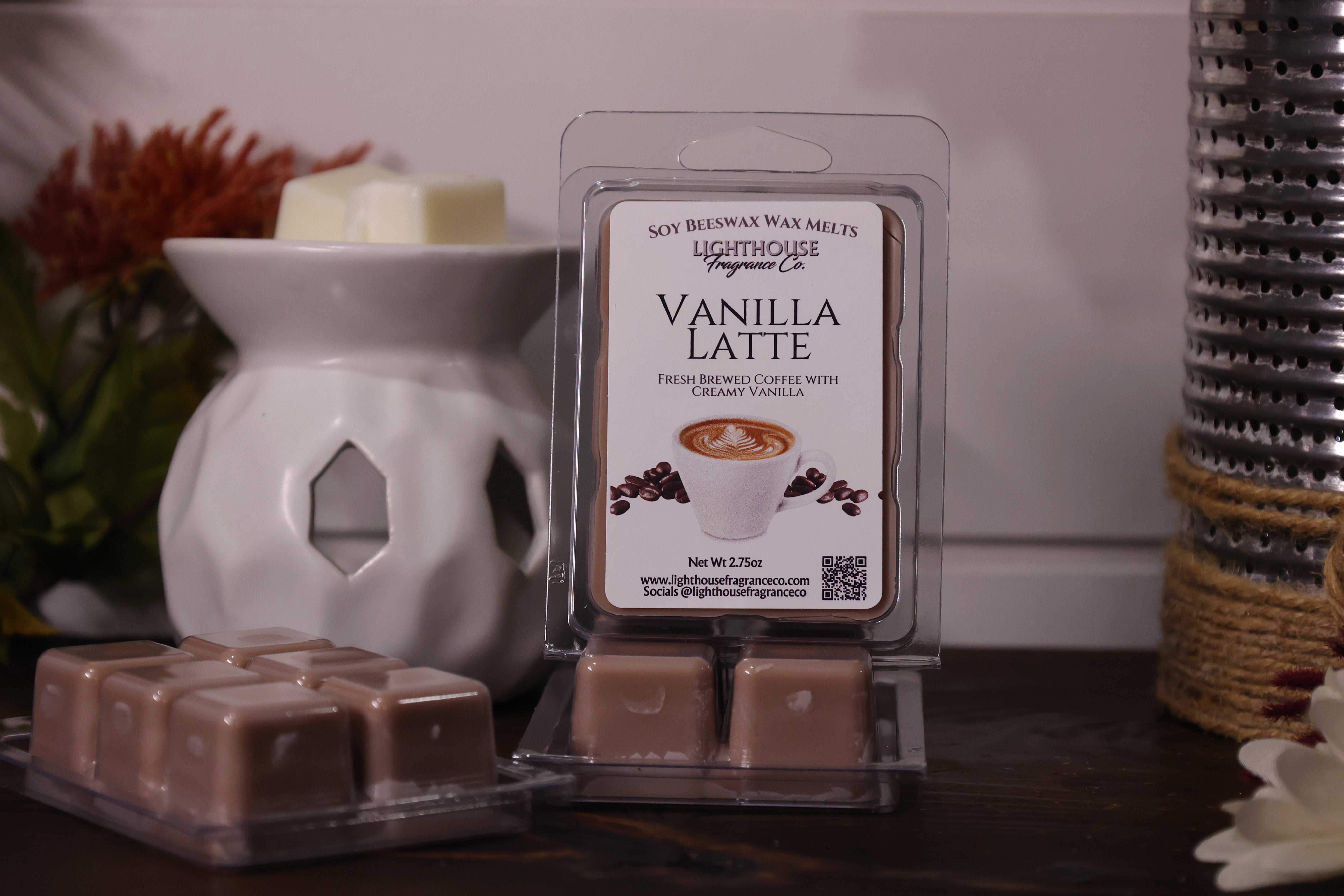 Vanilla Latte wax melt packaging with a white wax warmer and decorative items in the background.