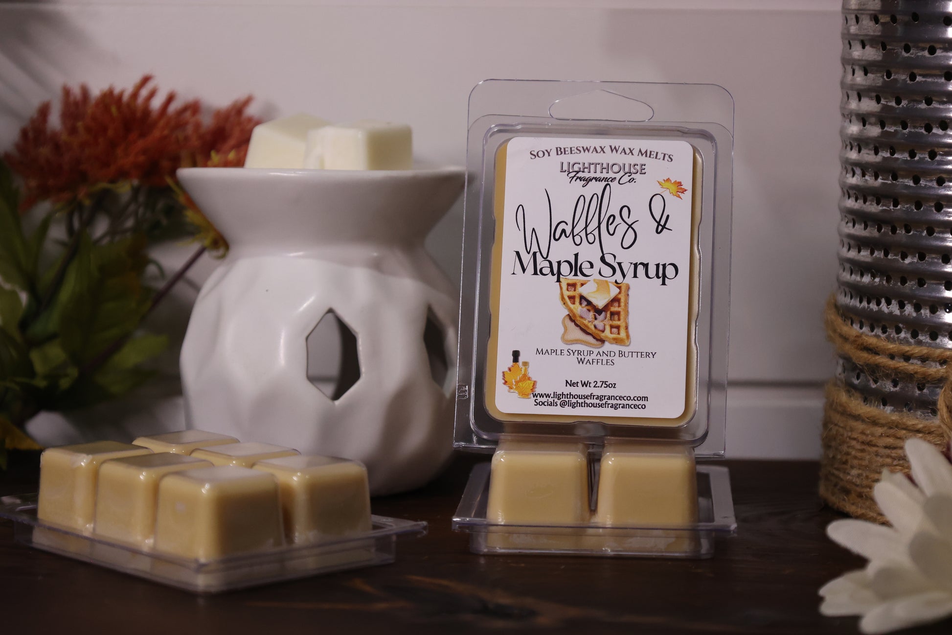 Wax melts packaging with 'Waffles & Maple Syrup' label next to a wax warmer on a decorative surface.