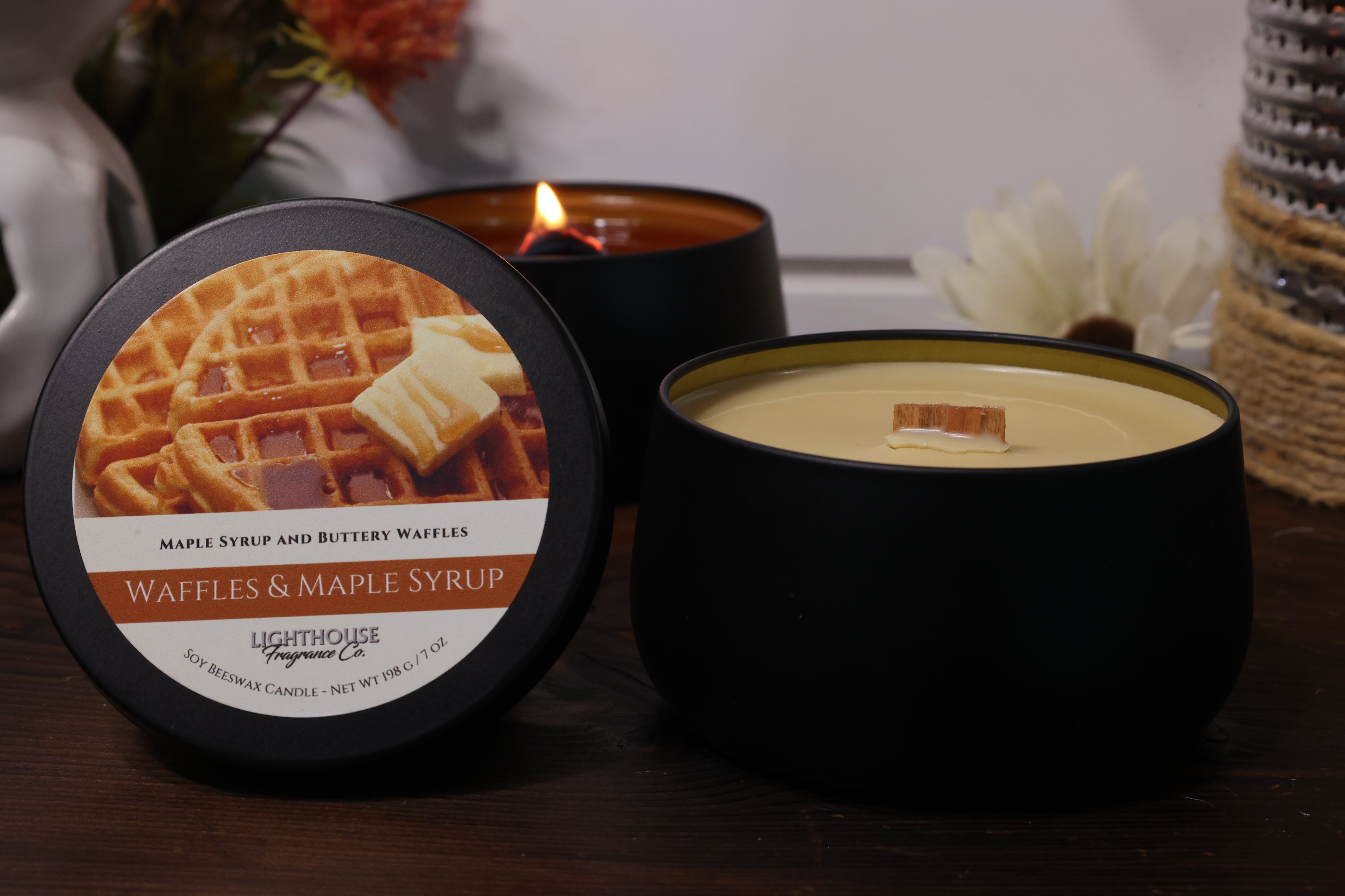Black candle with waffle and maple syrup label on a wooden surface