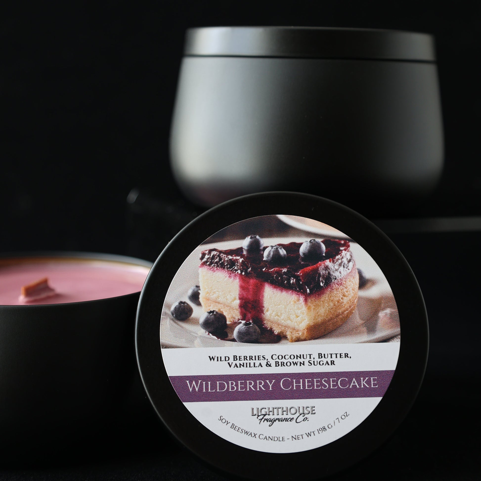 Close-up of a Wildberry Cheesecake candle container with a label on a black background