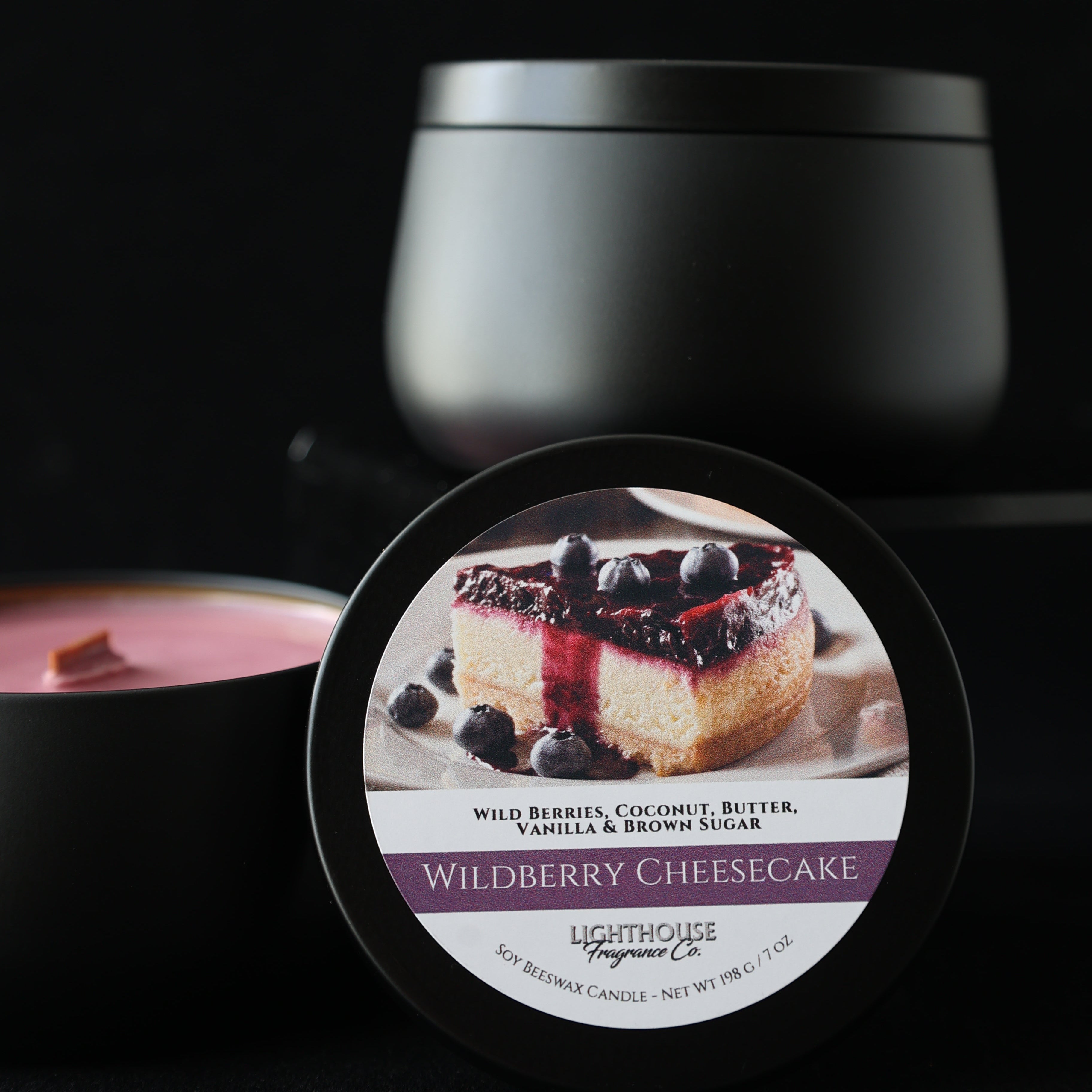 Close-up of a Wildberry Cheesecake candle container with a label on a black background