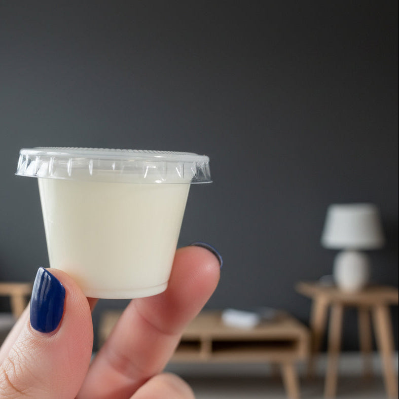 Hand holding a white plastic component against a neutral background